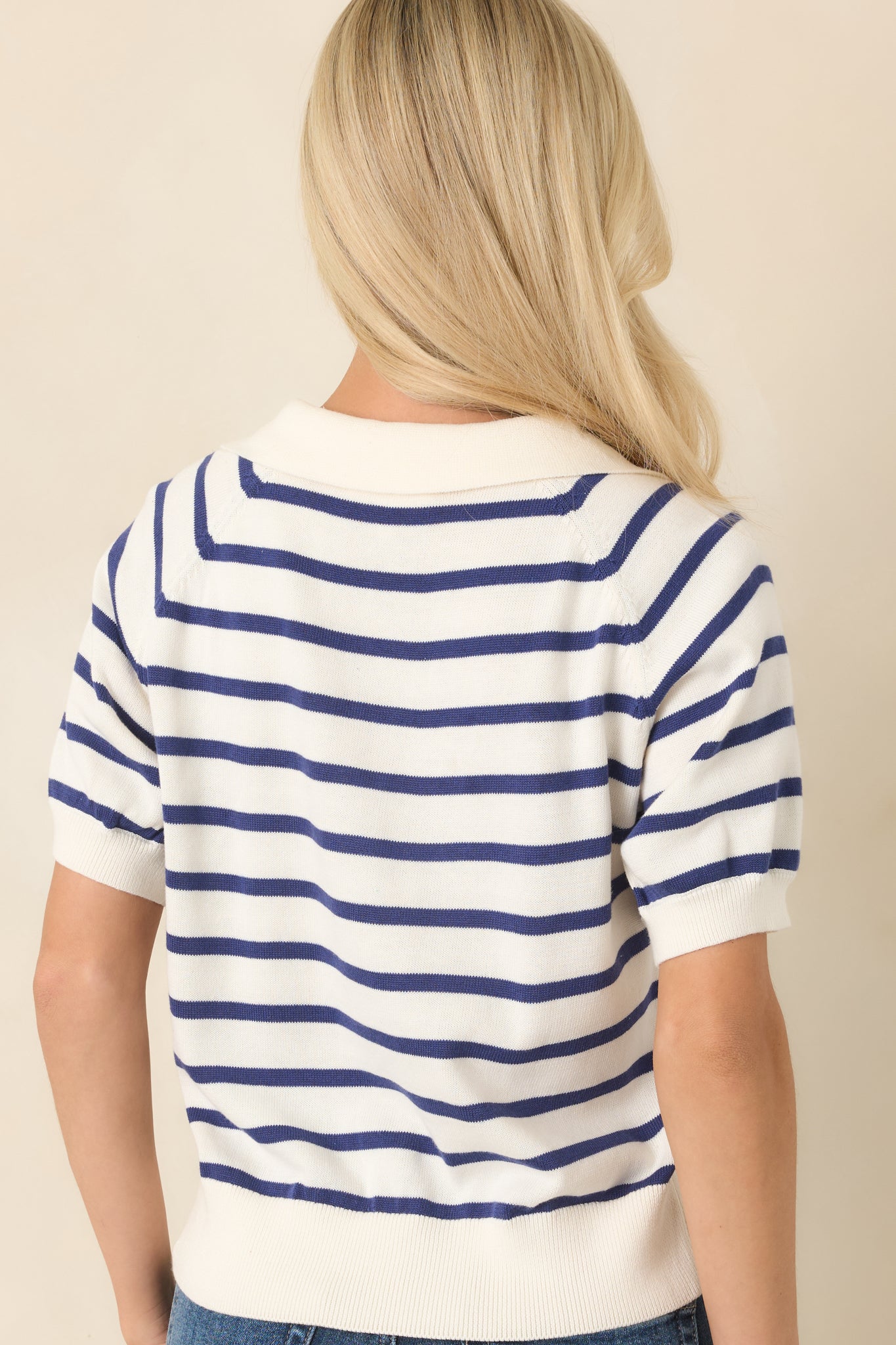 Rear view of the ivory knit top showcasing the horizontal stripe pattern and relaxed silhouette.