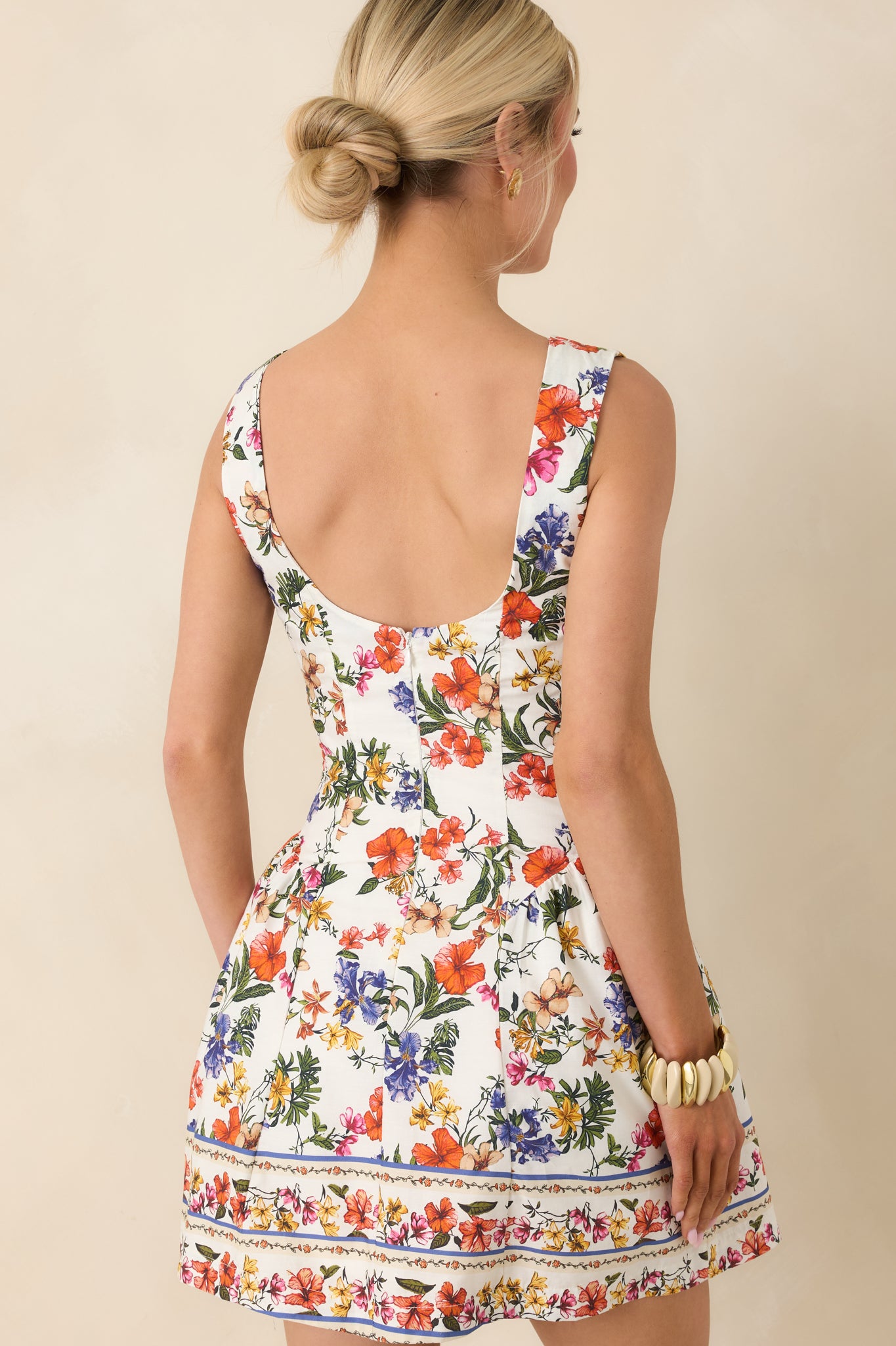 Rear view of ivory mini dress with sleeveless silhouette and clean tailored finish.