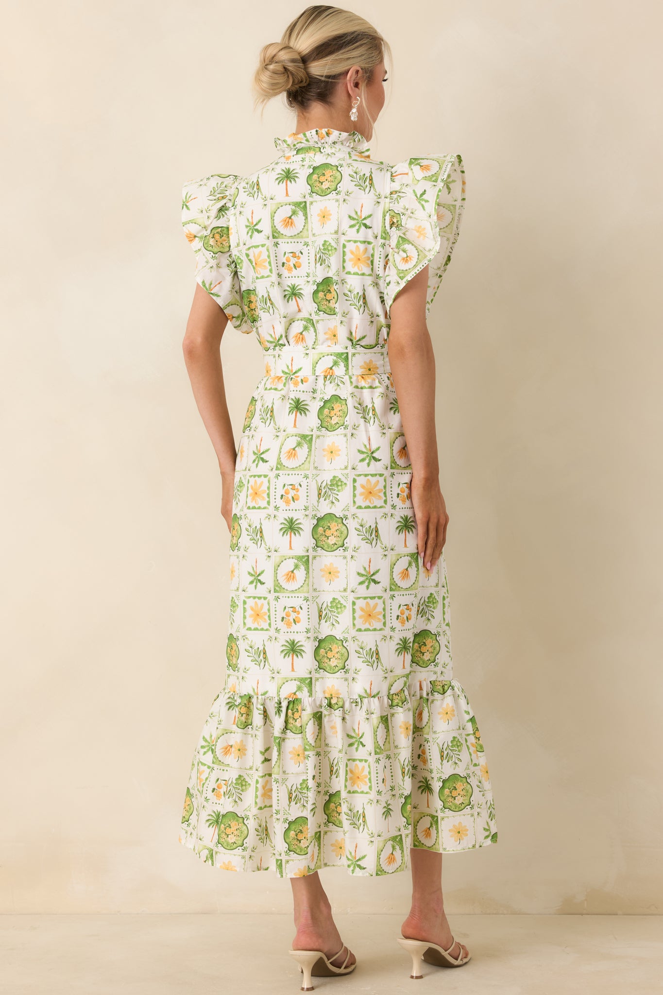 Rear view of maxi dress showing tiered skirt, flutter sleeves, and removable tie belt.