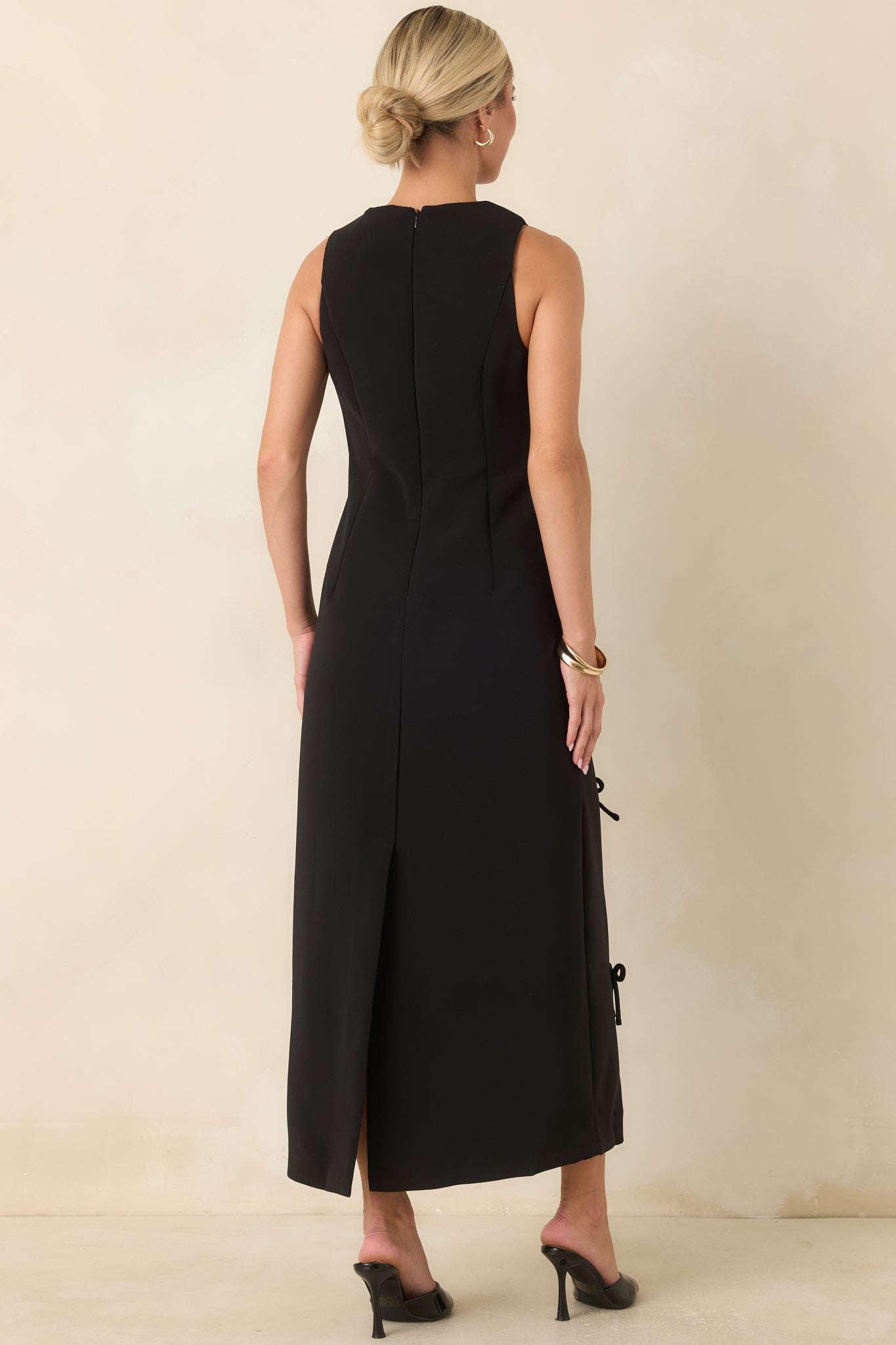 Rear view of the maxi dress showcasing the back zipper closure, rear slit, and fitted column silhouette.