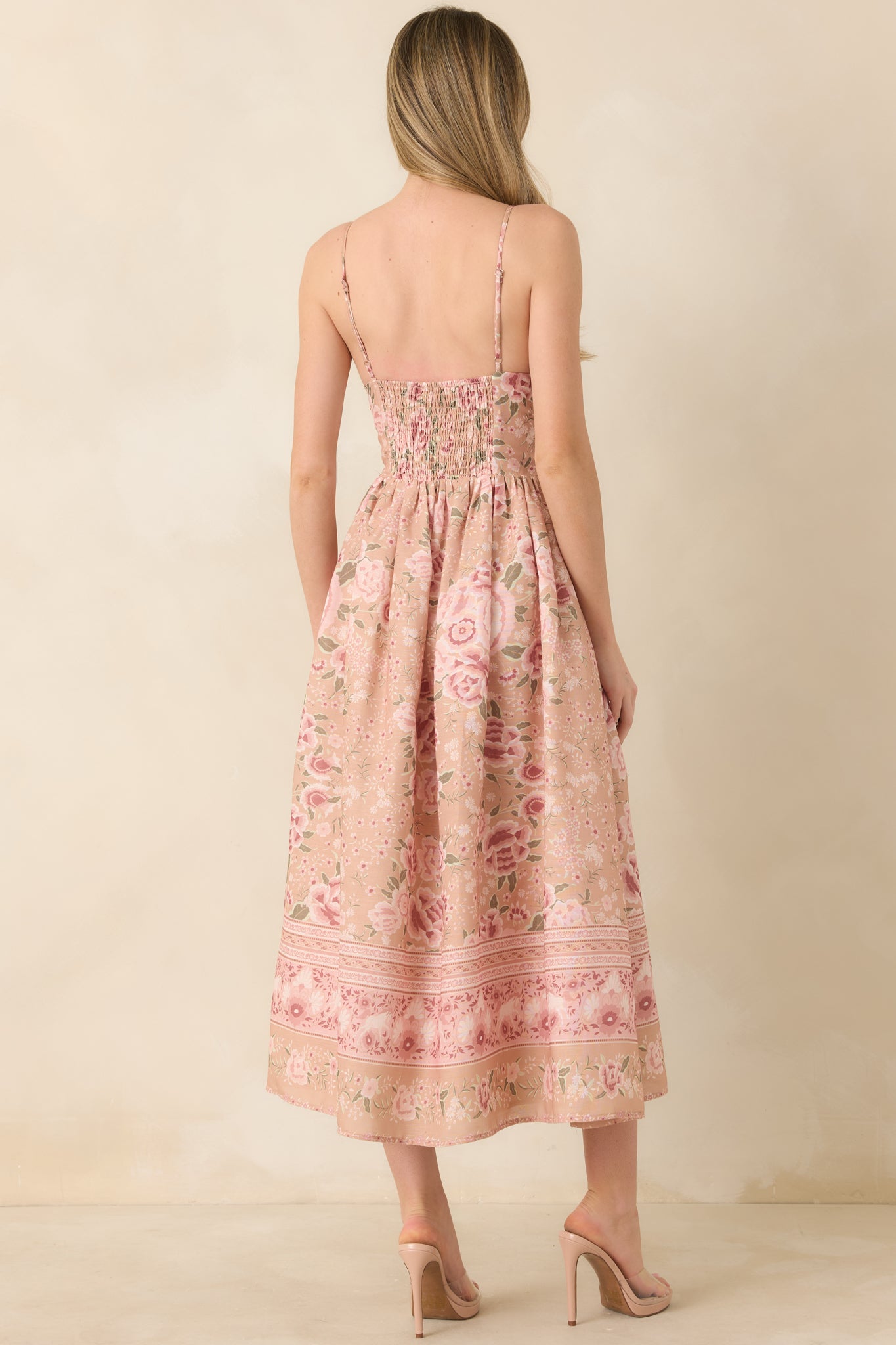 Rear view of floral midi dress with beige and pink tones and a flowing, lightweight silhouette.
