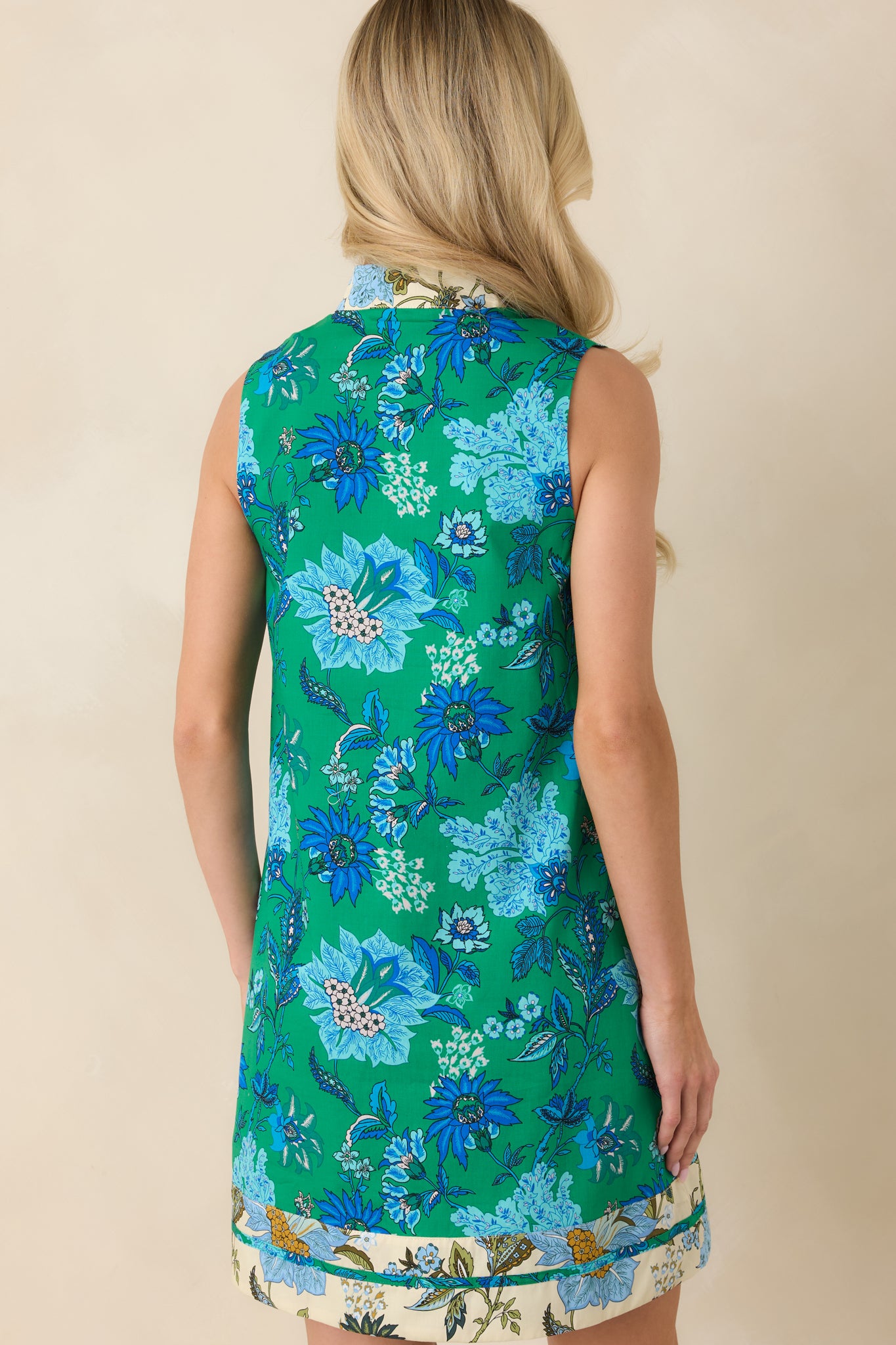 Rear view of mini dress with sleeveless shift silhouette and clean finish.
