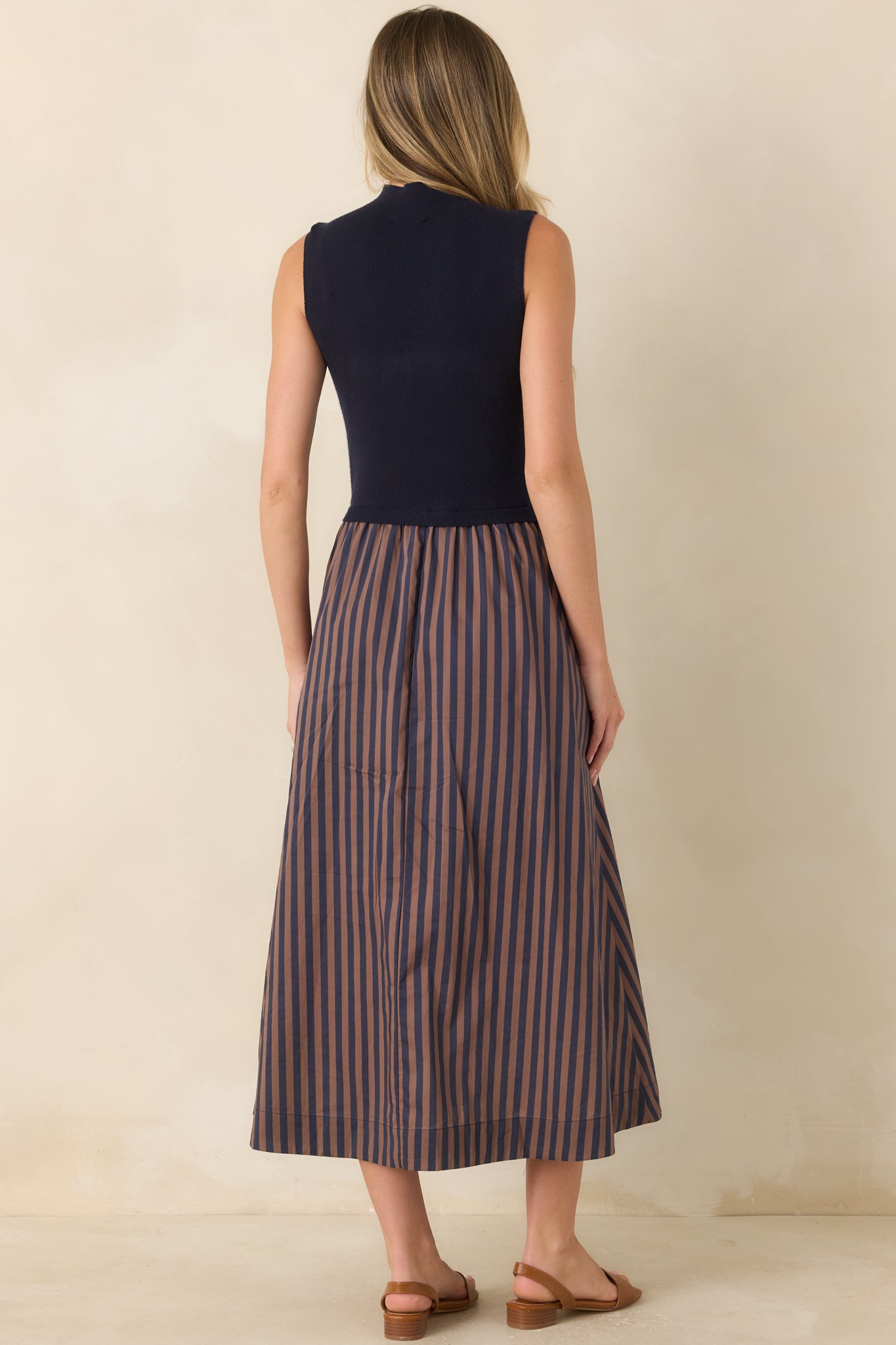 Rear view of the midi dress showcasing the sleeveless construction and the flowing A-line skirt with tan stripe accents.
