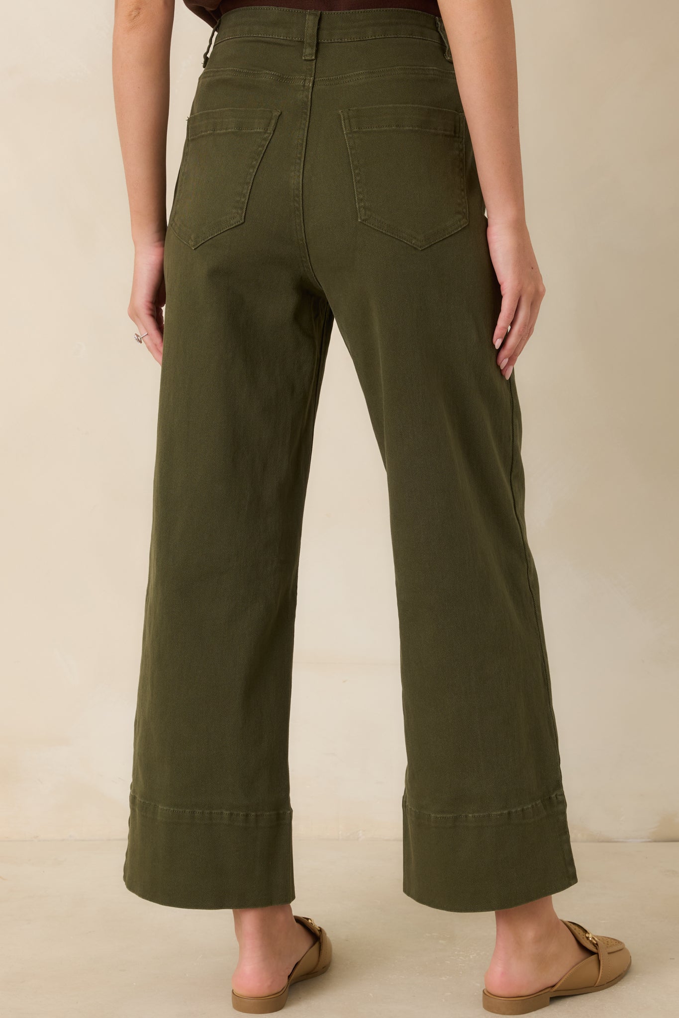 Rear view of the olive cropped pants featuring classic back patch pockets, belt loops, and a structured wide-leg shape.