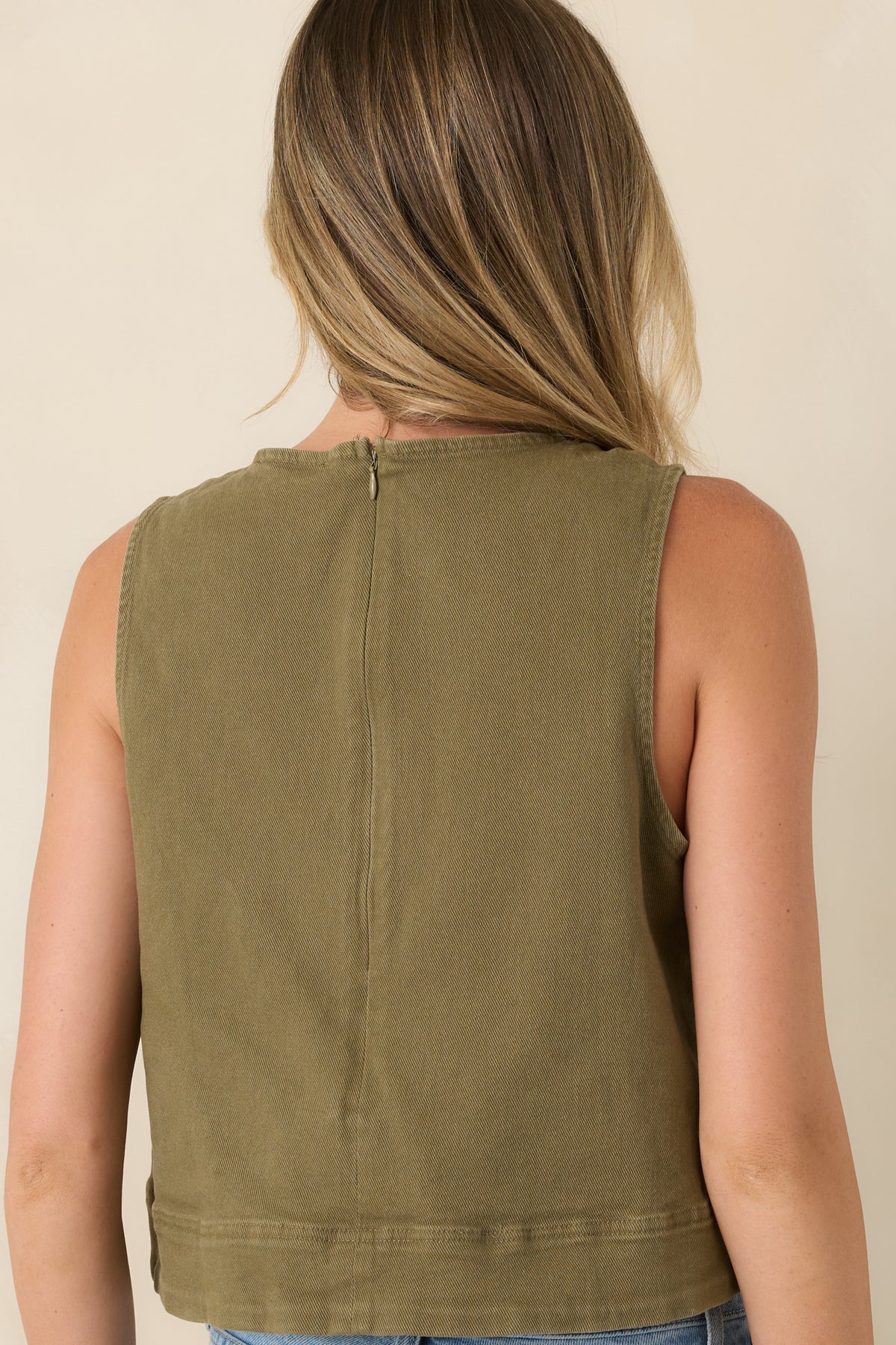 Rear view of the olive denim top showcasing the clean back zipper and smooth silhouette.