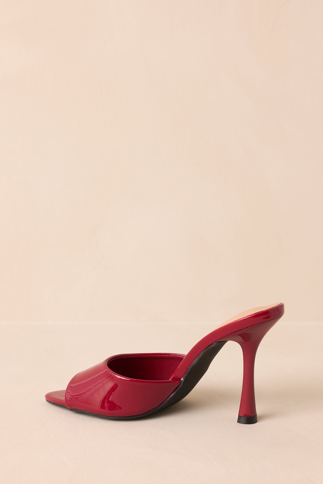 Rear view of red open-toe mule heels showing stiletto heels and smooth faux leather finish.