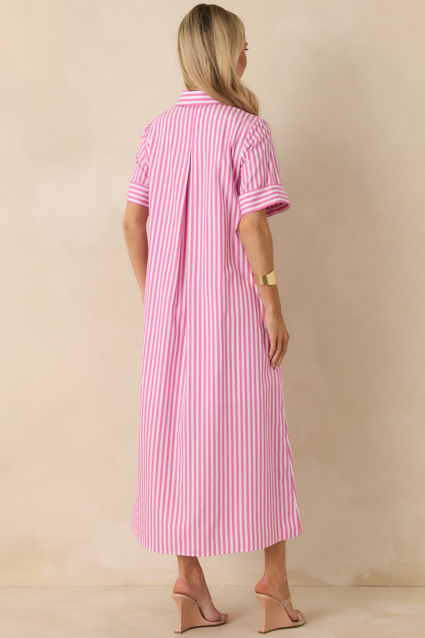 Rear view of striped shirt dress highlighting center back pleat, cuffed sleeves, and flowing maxi hem.