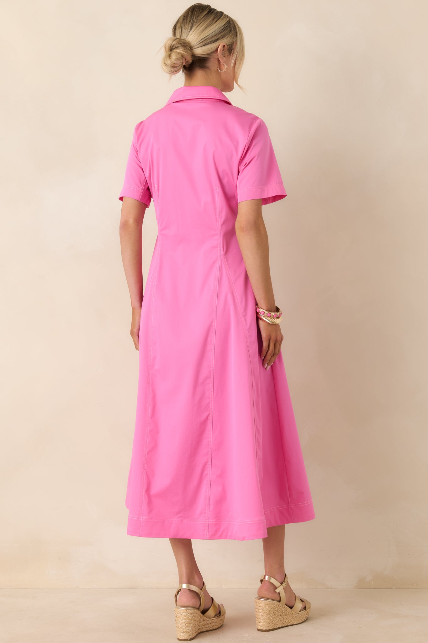Rear view of short-sleeve midi dress with lightweight fabric and structured silhouette.