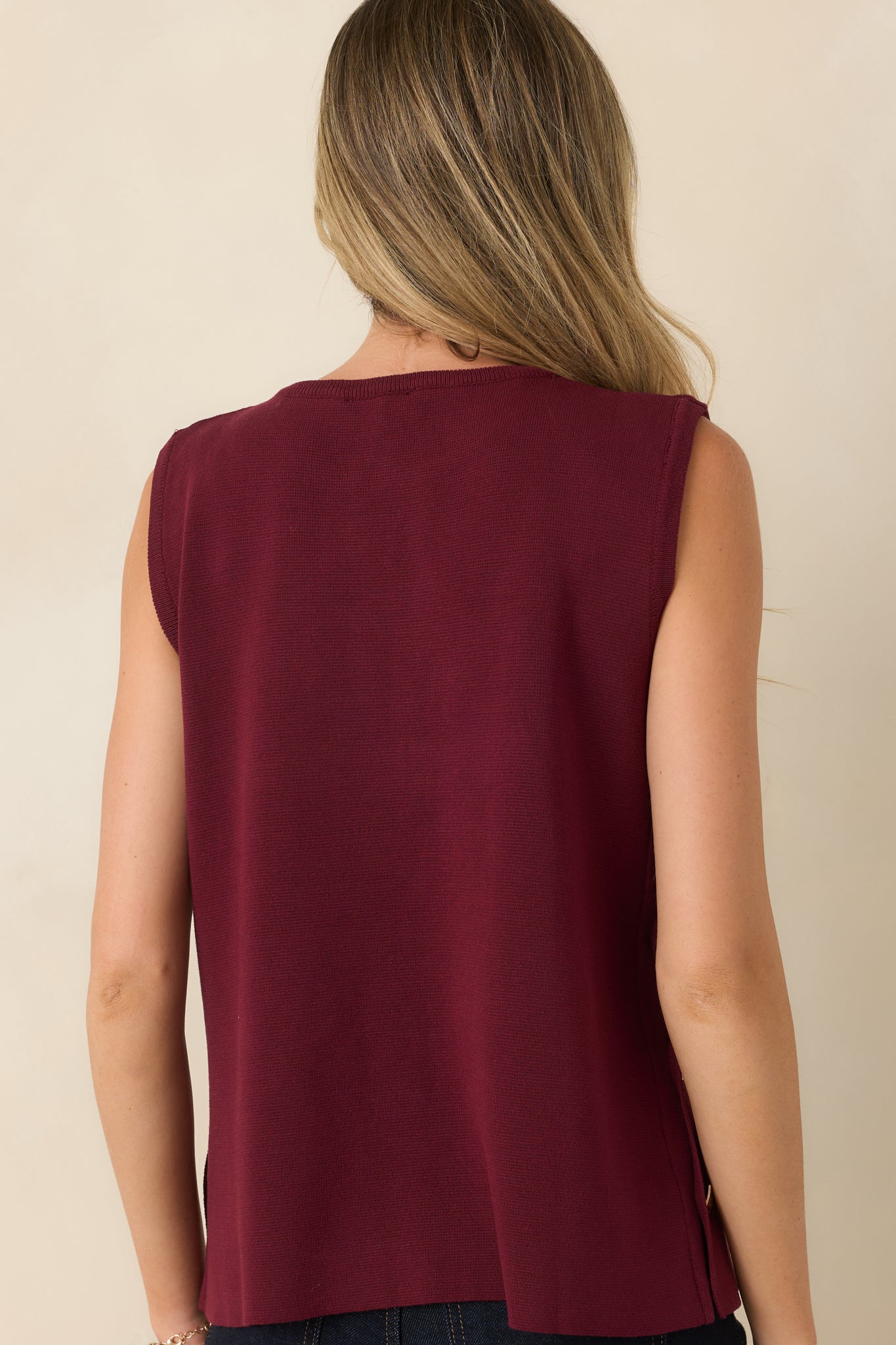 Rear view of the sleeveless sweater knit top showcasing the smooth drape, relaxed silhouette, and clean finish.