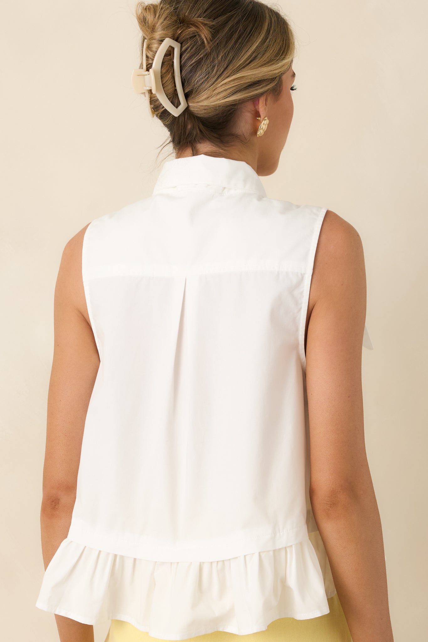 Rear view of sleeveless top with relaxed fit and ruffle hem.