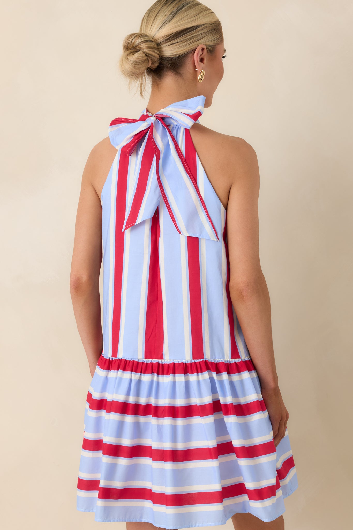 Rear view of striped mini dress with halter tie closure, subtle keyhole, and flowing tiered skirt.