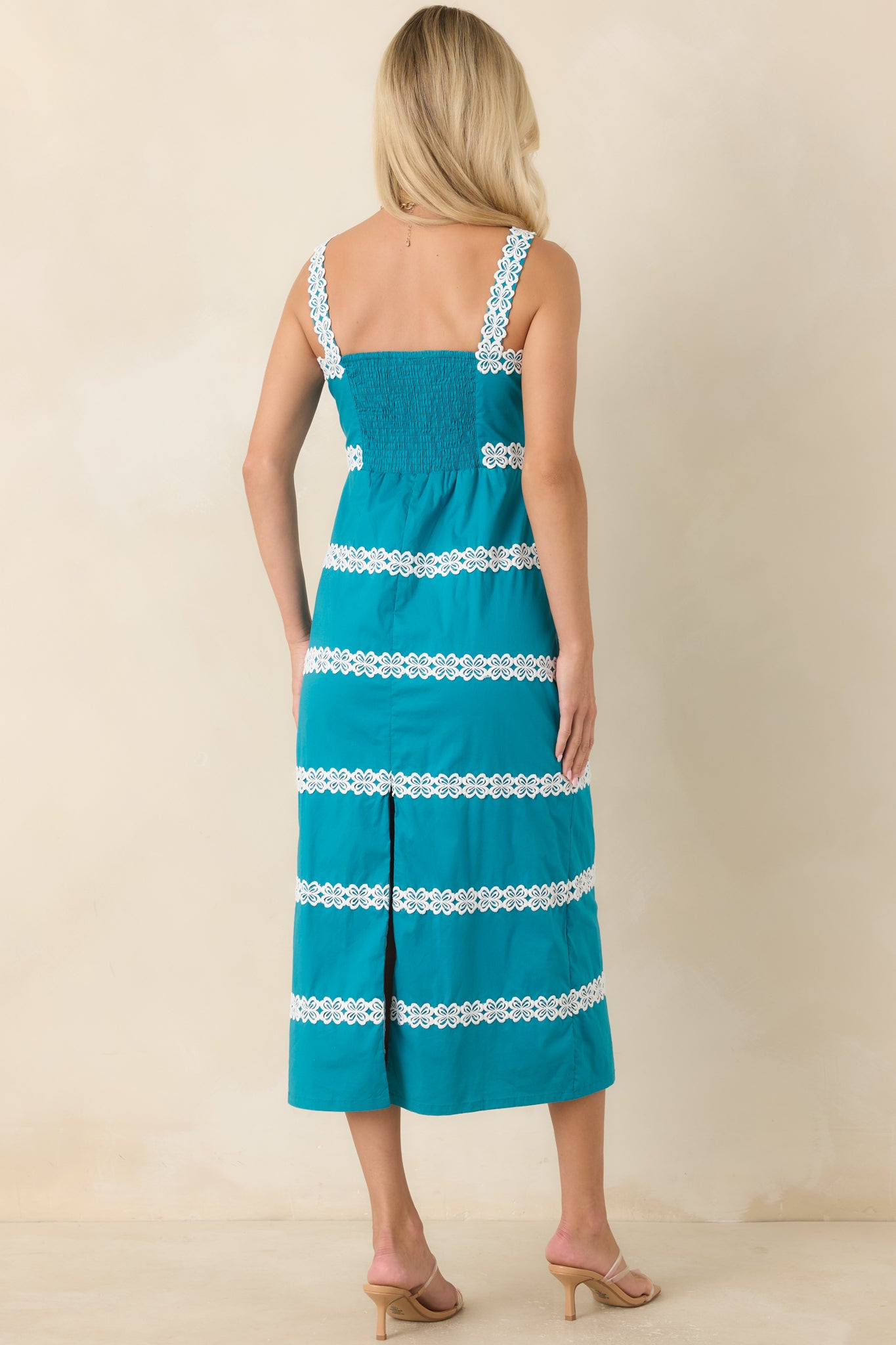 Rear view of the teal midi dress showcasing the smocked back panel and back slit detail.