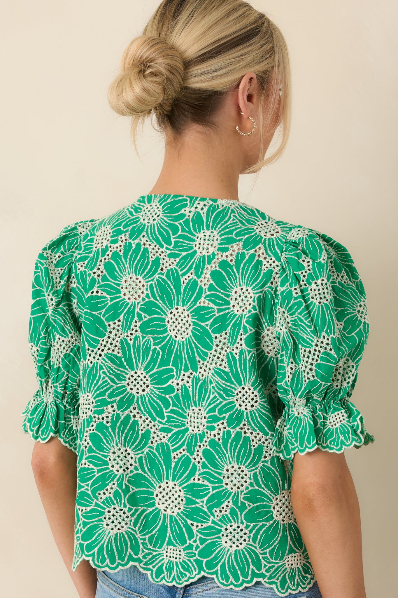Rear view of the embroidered top with puff sleeves and button-back closure.