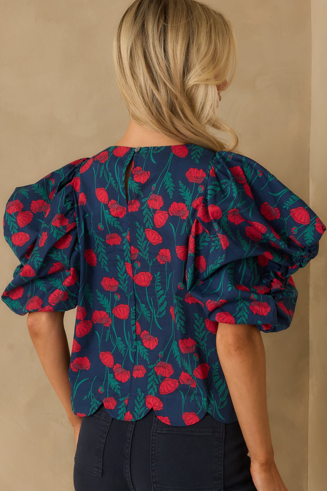 Rear view of the floral top with keyhole button closure and puff sleeves.