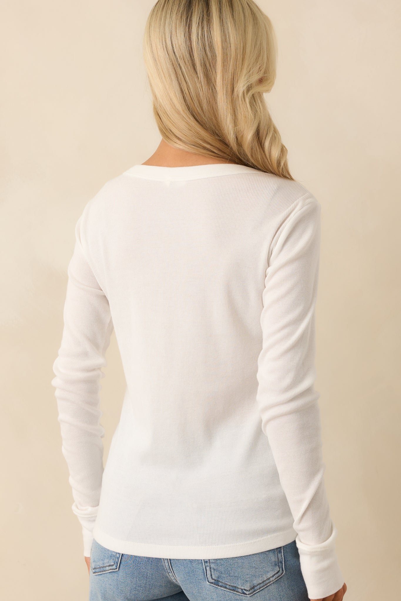 Rear view of the ivory tee displaying the smooth back panel, long sleeves, and consistent ribbed fabric throughout.