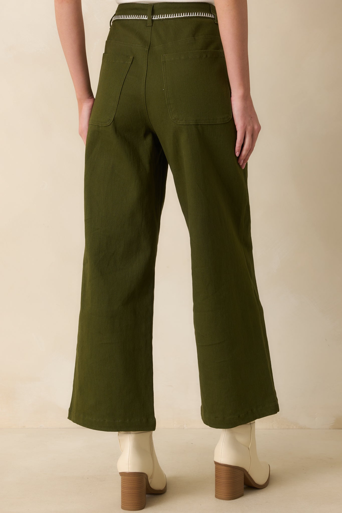 Rear view of the olive green jeans showing the back patch pockets and seam details.