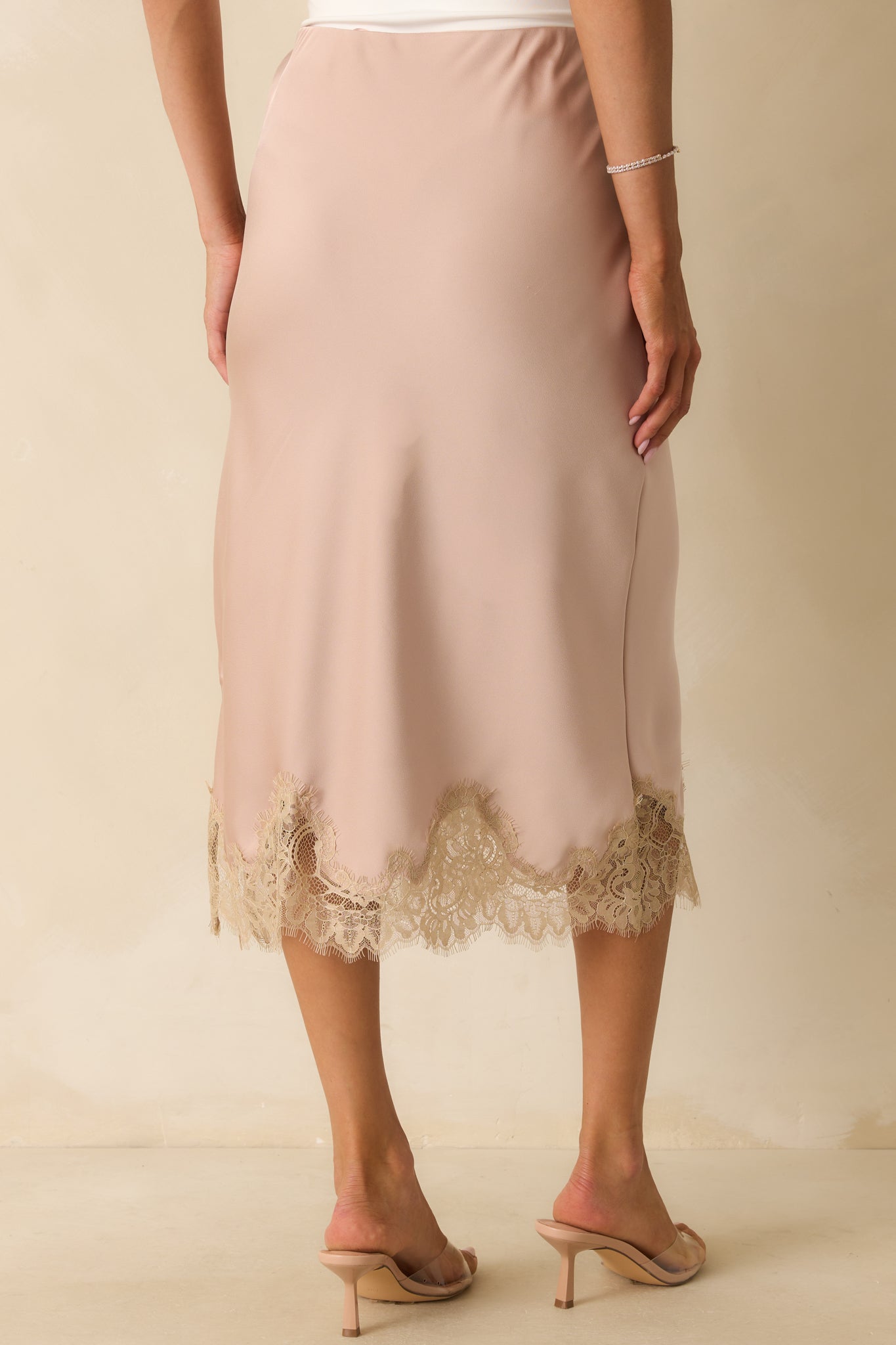 Rear view of the dusty pink midi skirt showing the straight silhouette, pull-on design, and lace-trimmed hem.