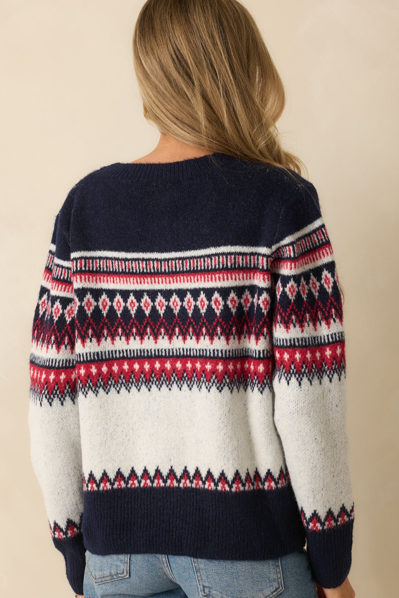 Rear view of white knit cardigan showing Fair Isle pattern across shoulders and ribbed hem without buttons.