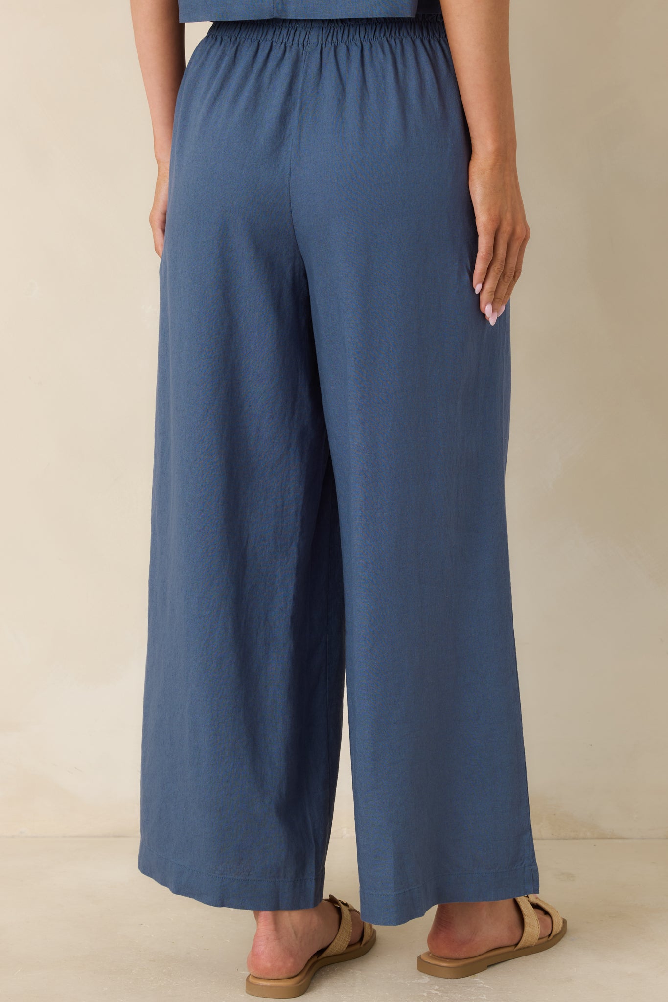 Rear view of wide-leg pants showing high-rise elastic waistband and easy flowing silhouette.