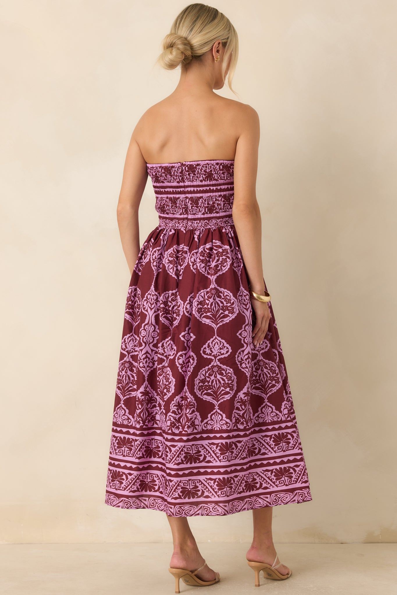 Rear view of the wine and orchid pink midi dress showcasing the smocked back, concealed zipper, and flowing gathered skirt.