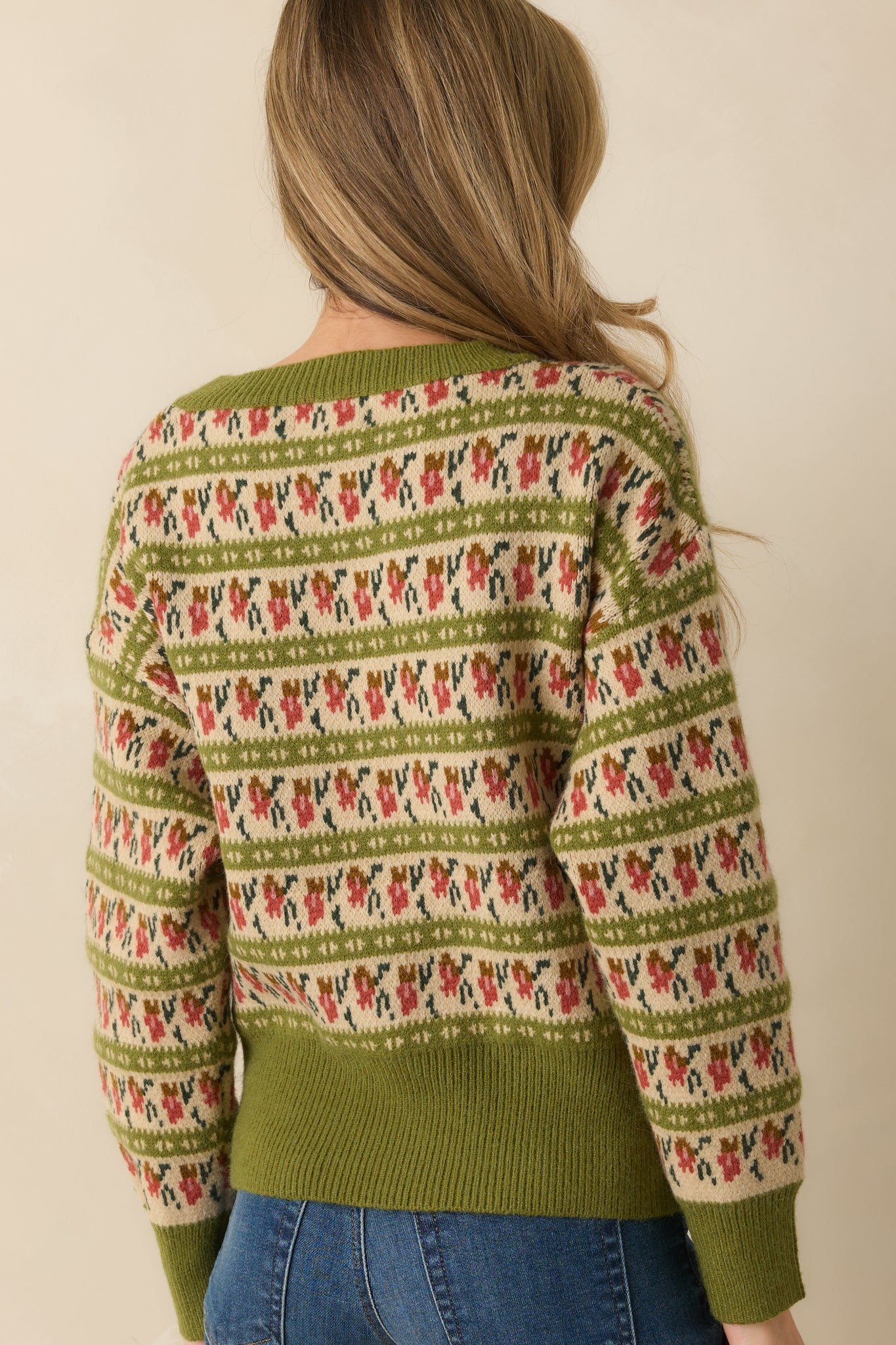 Rear view of the olive green sweater showing the allover Fair Isle pattern and ribbed trim edges.