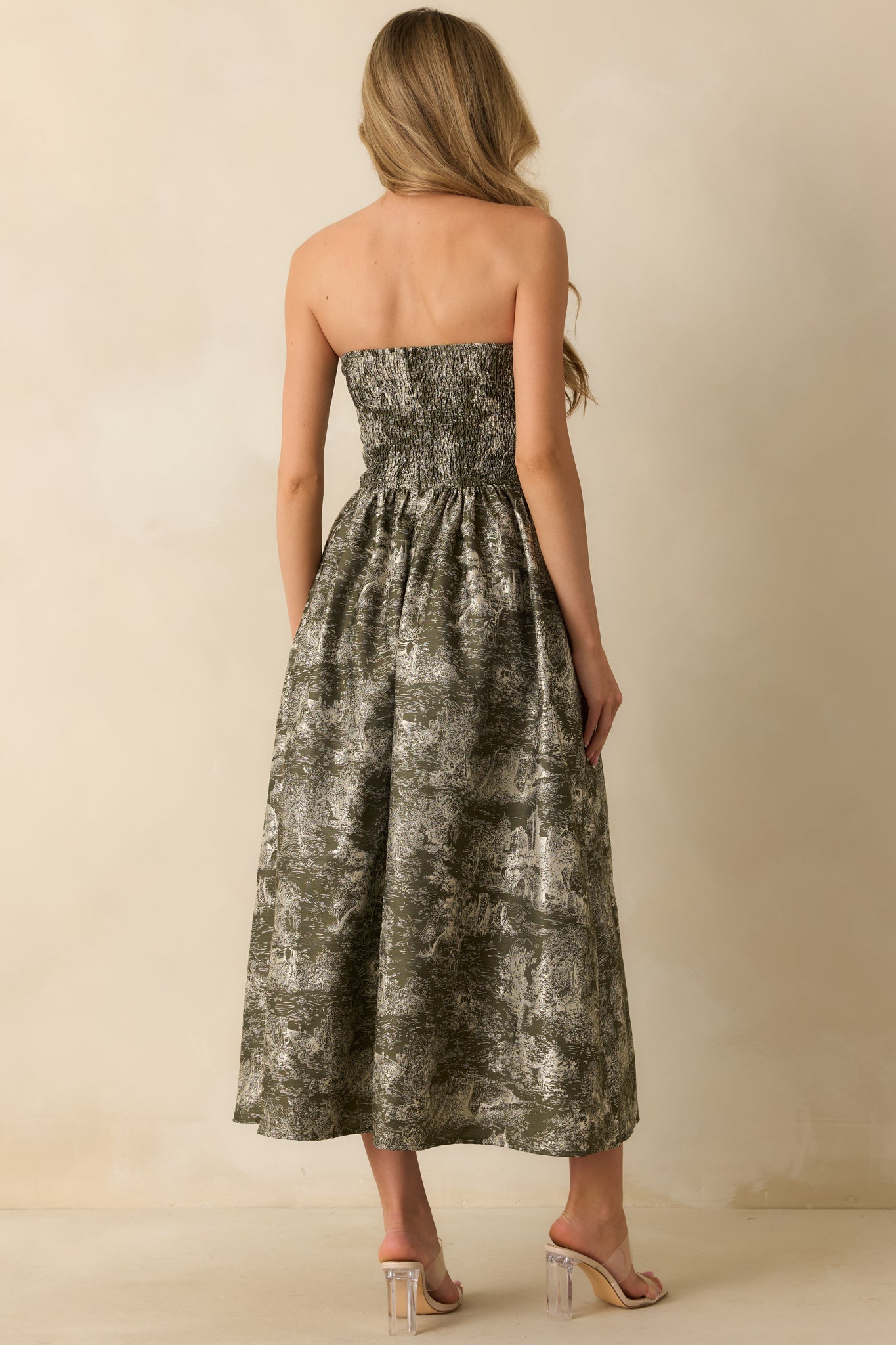 Rear view of the olive strapless midi dress showing the hidden back zipper, full lining, and voluminous A-line skirt.