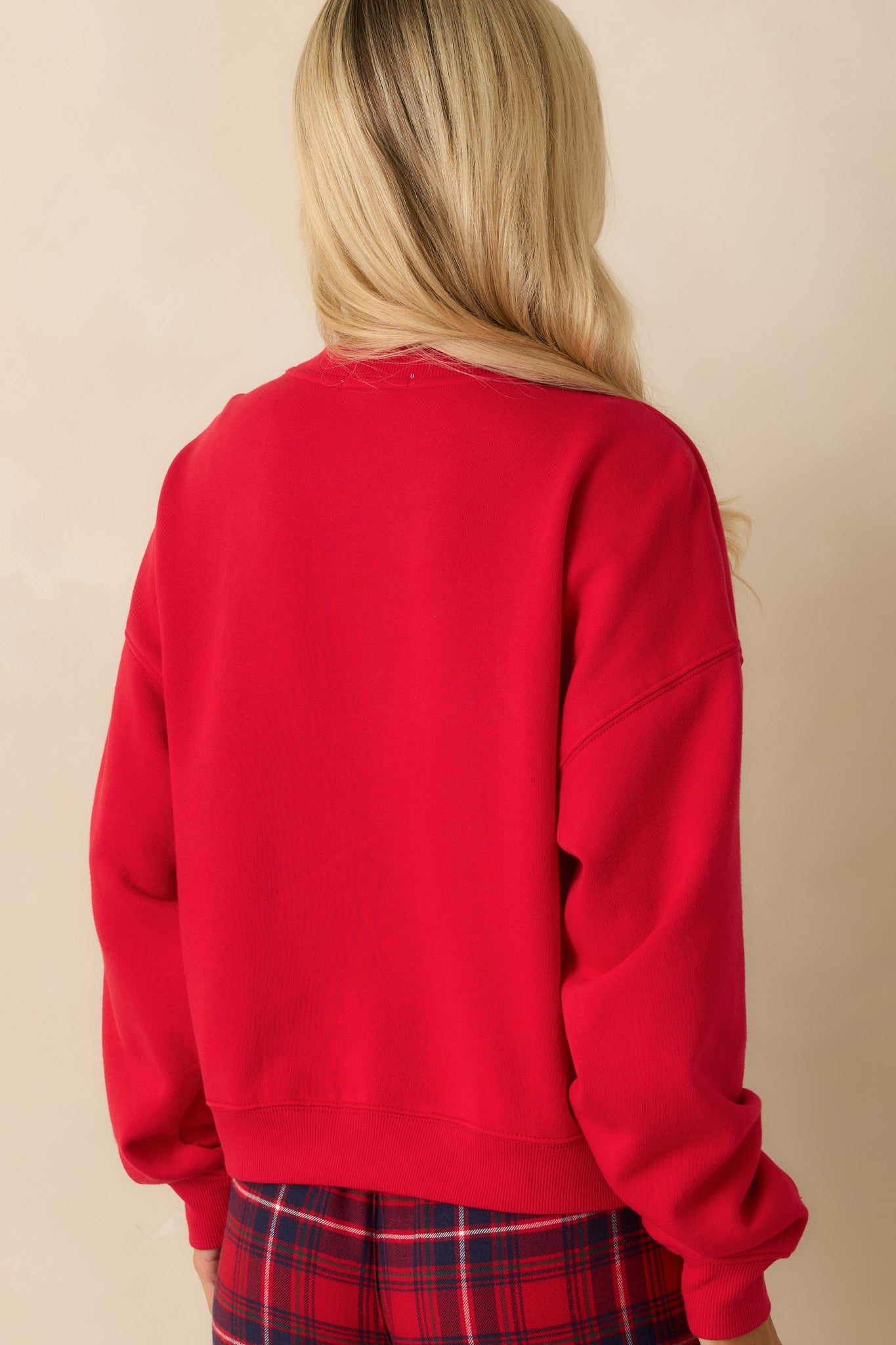 Rear view of oversized red sweatshirt, showing long sleeves, relaxed silhouette, and smooth midweight fleece finish.