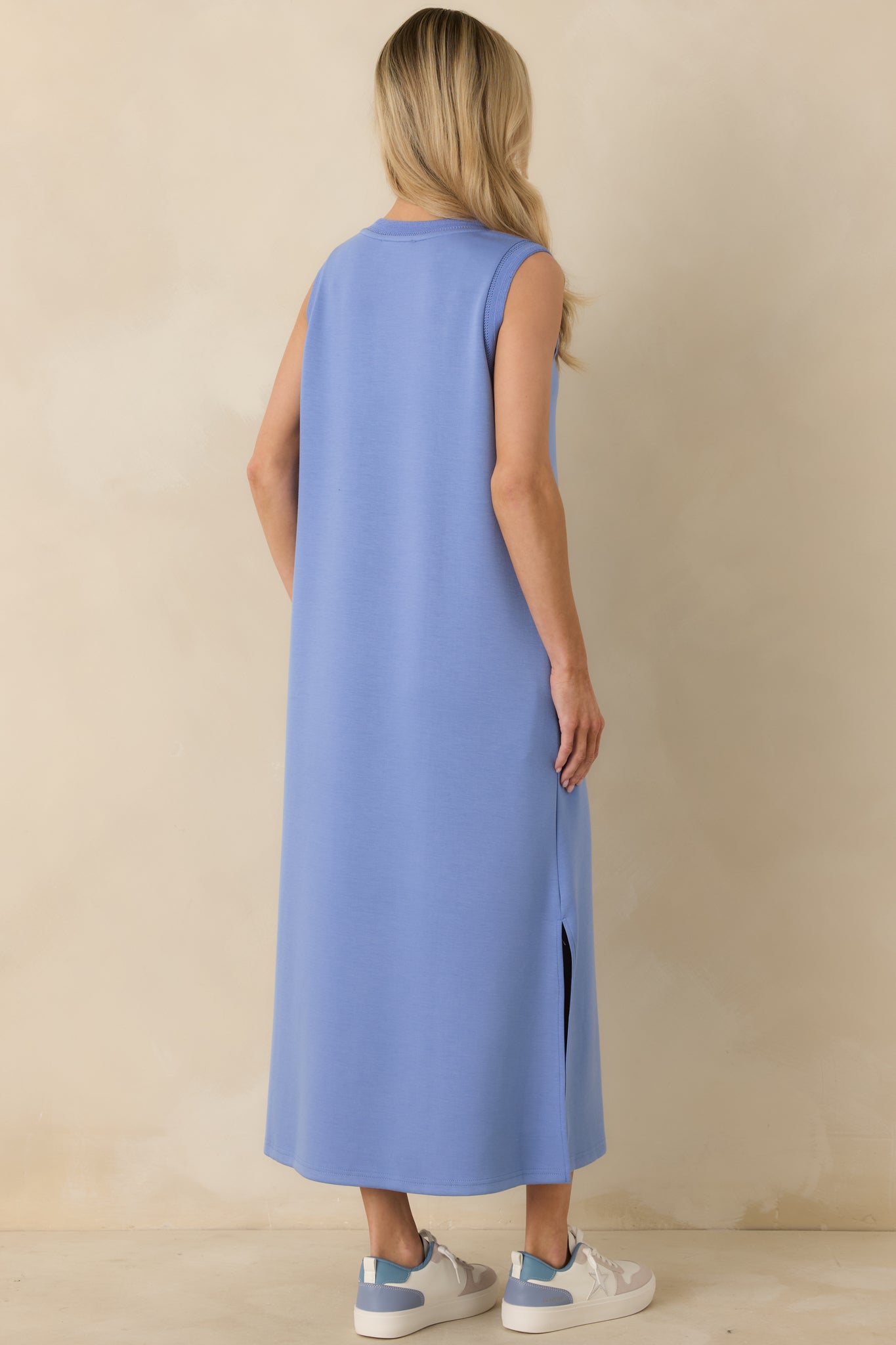 Rear view of the periwinkle blue maxi dress highlighting the straight silhouette, side slits, and fluid drape of the jersey knit fabric.