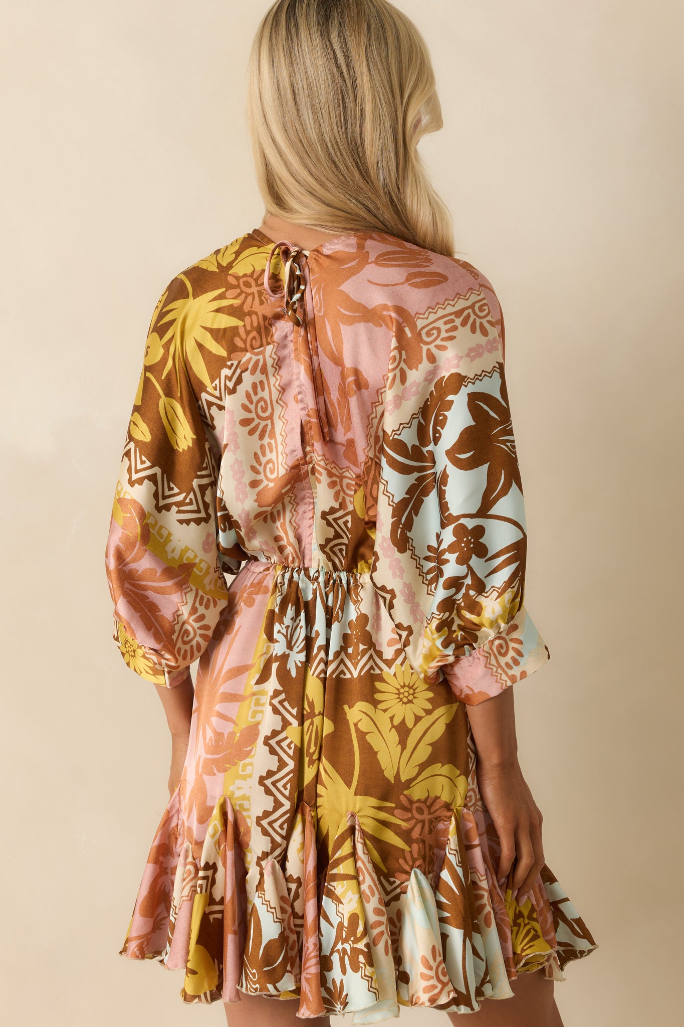 Rear view of the pink coral mini dress with a self-tie keyhole closure and flared skirt.