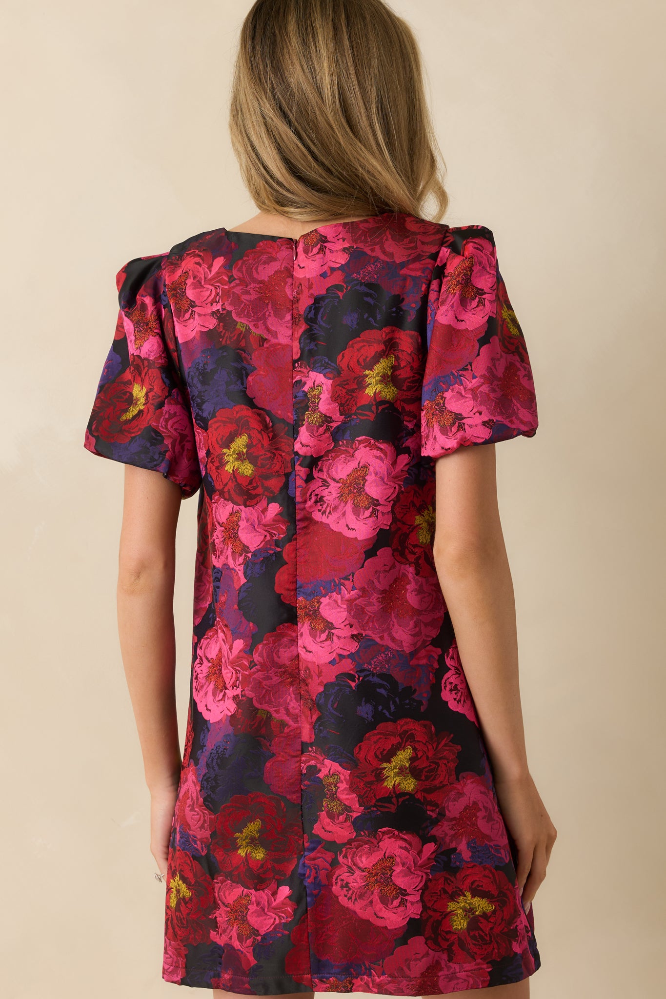 Rear view of the pink mini dress showing the hidden zipper closure and puff sleeve design.