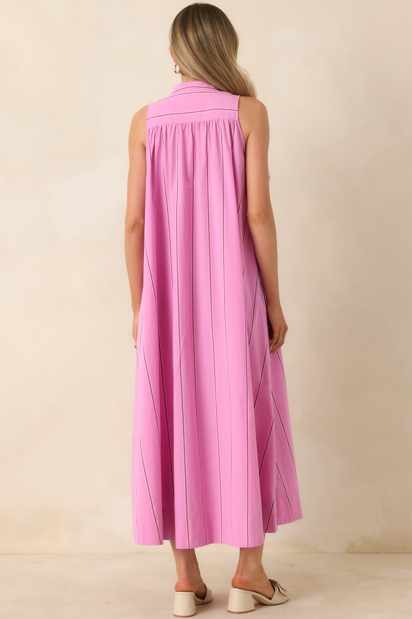 Rear view of pink striped maxi dress with flowing silhouette and gathered yoke.