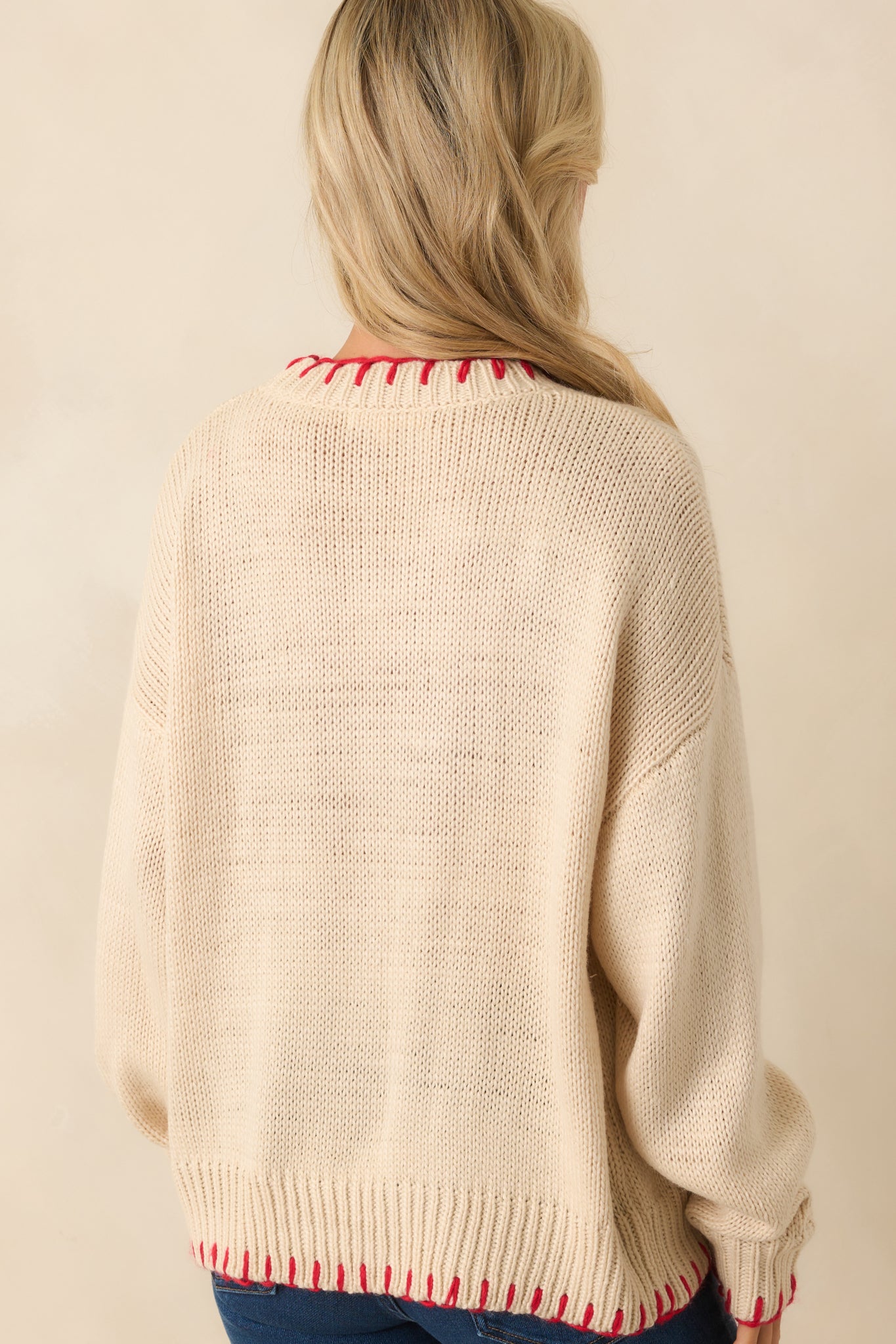 Rear view of the pullover sweater in solid ecru beige with ribbed trim.