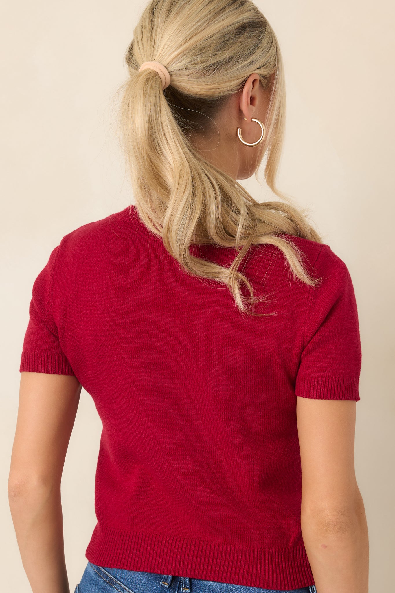 Rear view of the rayon-blend knit top showcasing its crew neckline, short sleeves, ribbed cuffs, and ribbed hem.
