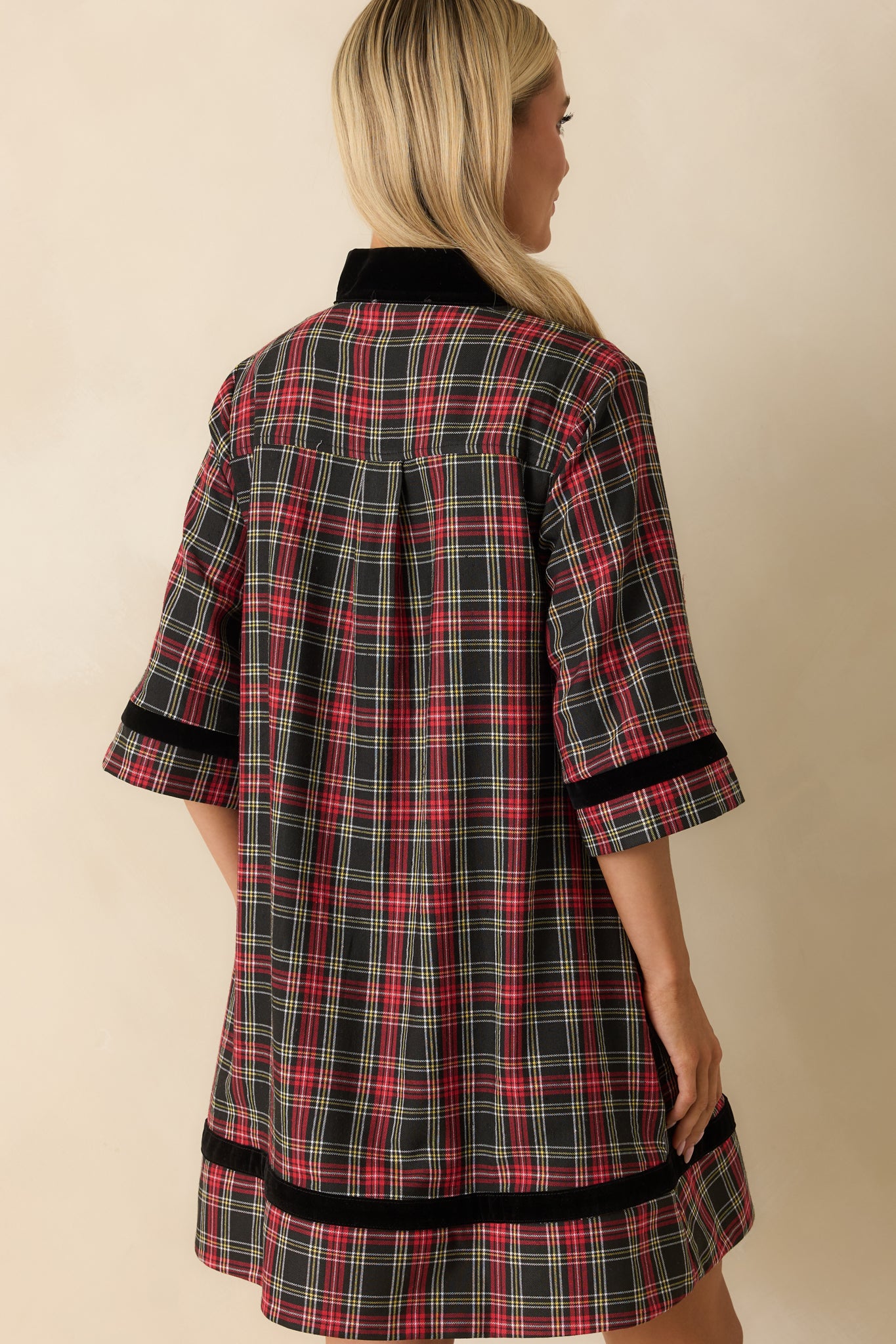 Rear view of red and black plaid mini dress showing elbow-length sleeves, fully lined back, and relaxed A-line fit.