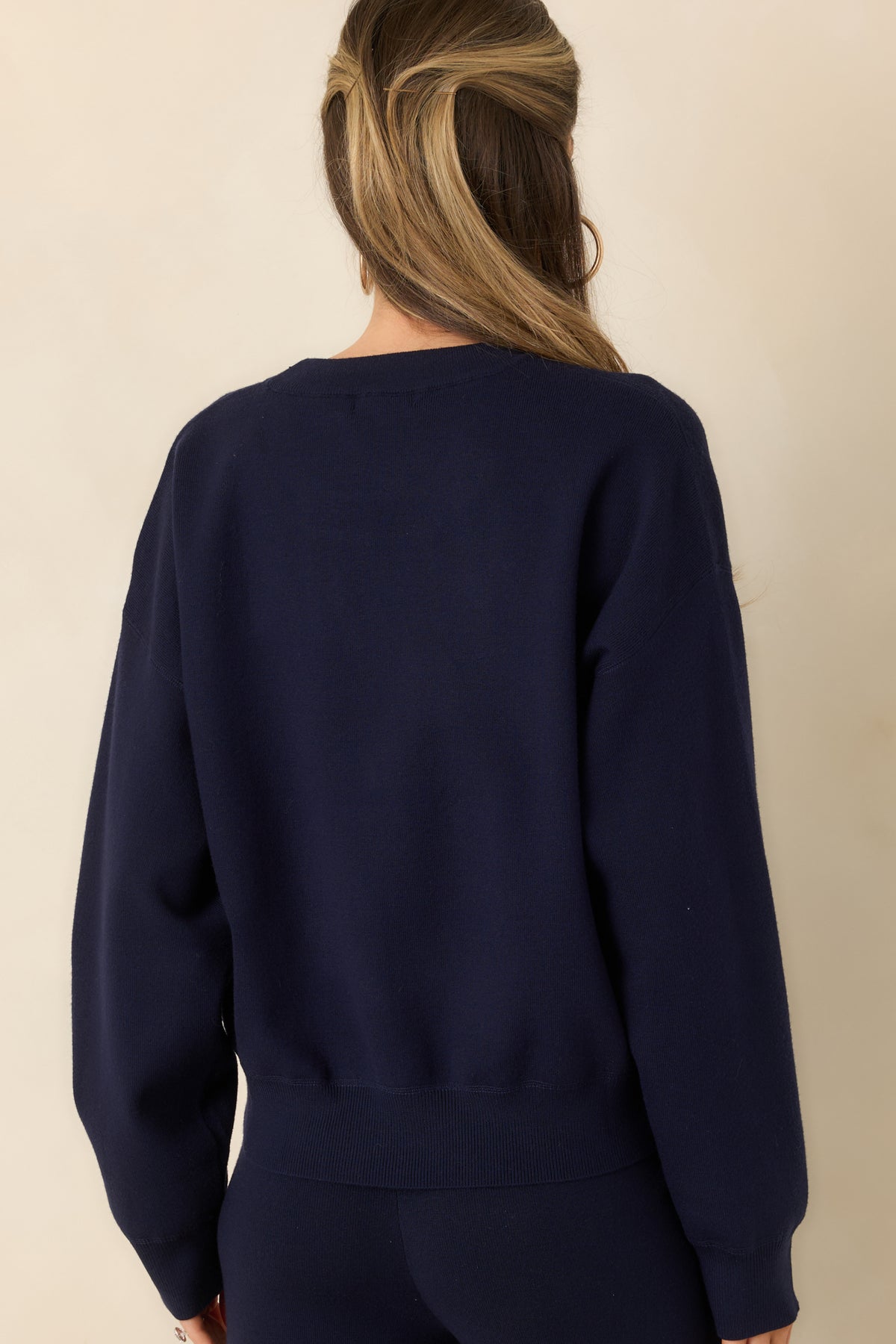 Rear view of the relaxed pullover highlighting its dropped shoulders, long sleeves, and ribbed hem.
