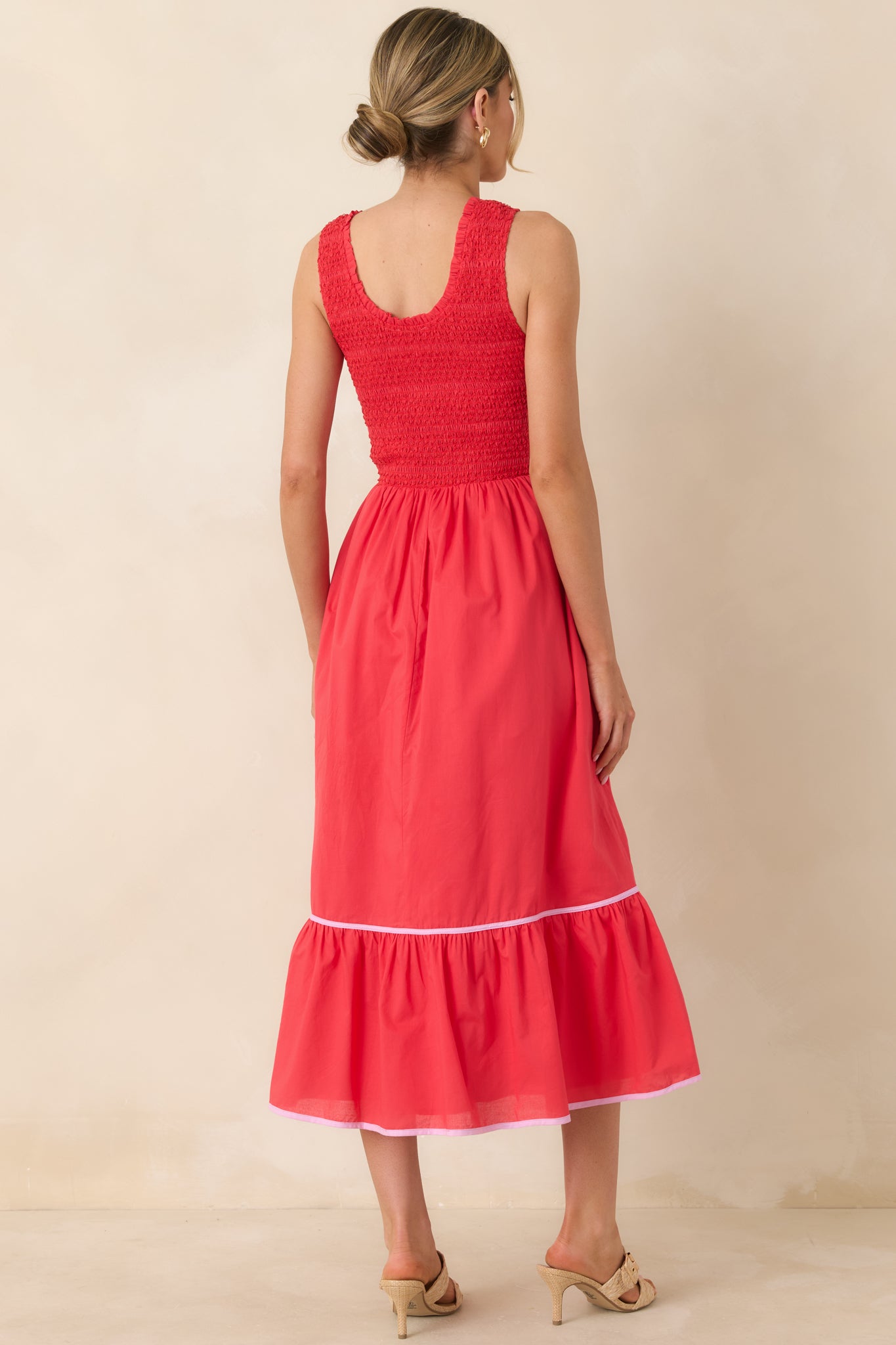 Rear view of the red midi dress showcasing the smocked bodice and flowing tiered skirt.