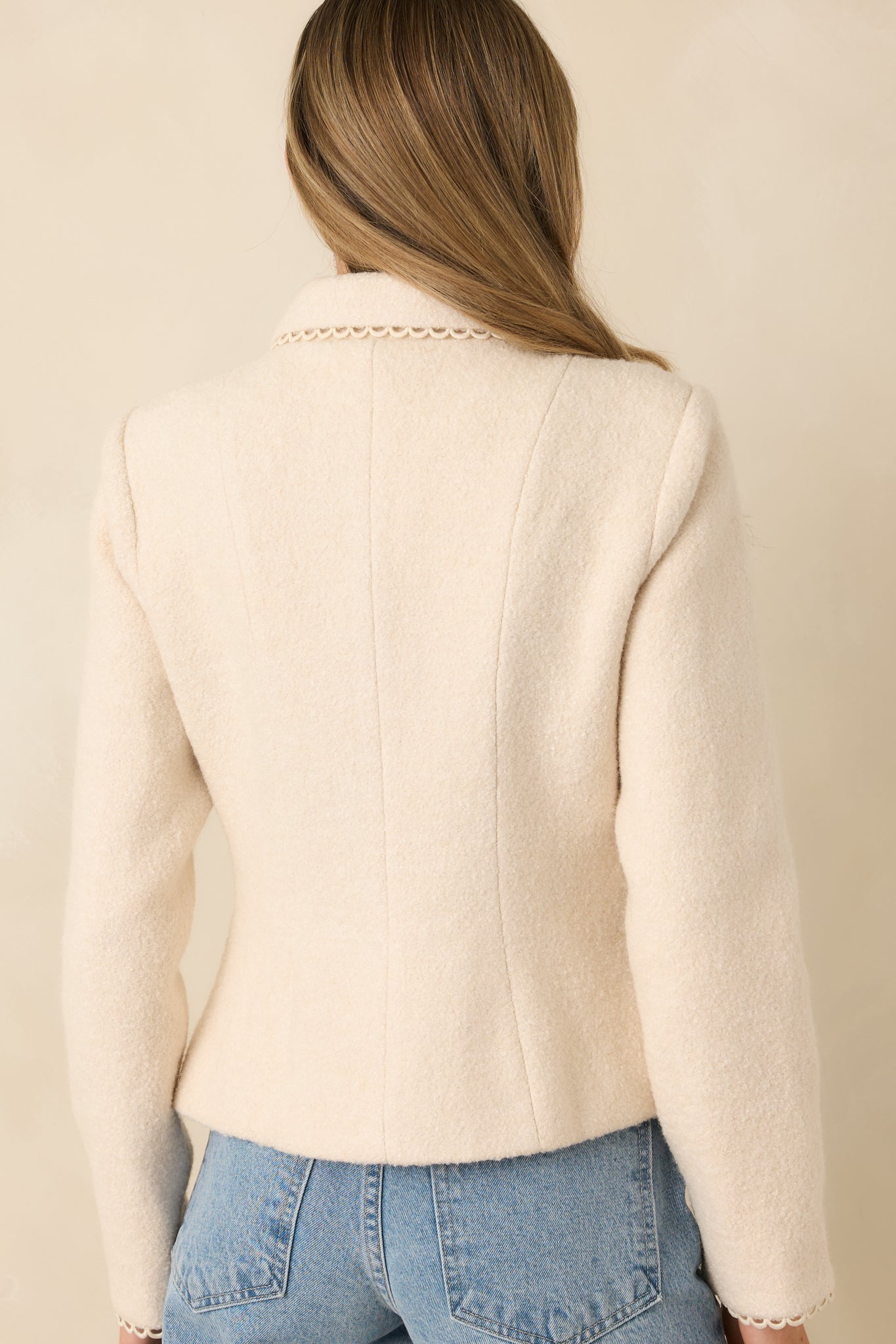 Rear view of natural wool blend jacket showing lightly structured silhouette and smooth lined finish.