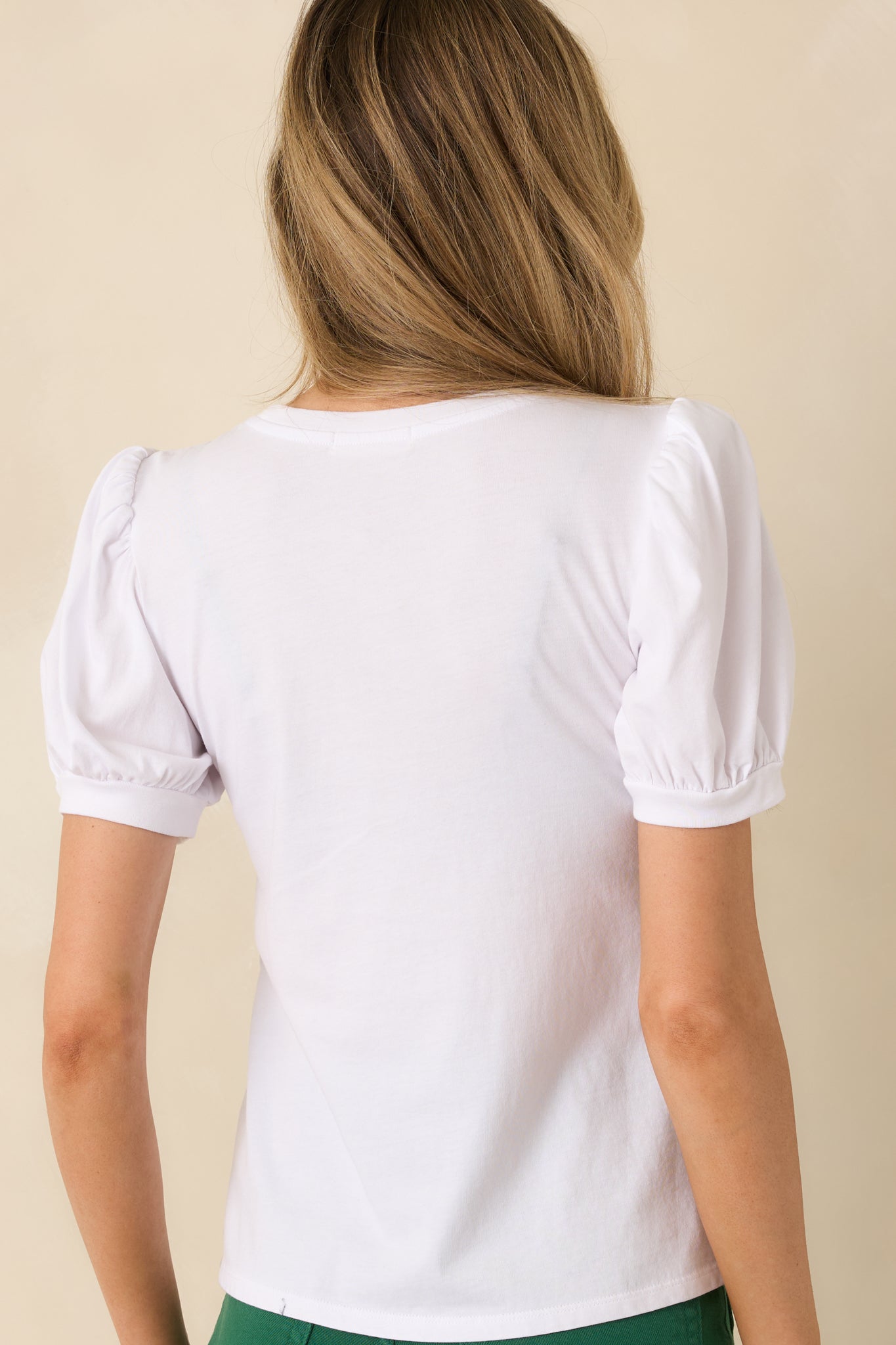 White cotton knit top with gathered puff sleeves continuing into a straight, classic rear silhouette.