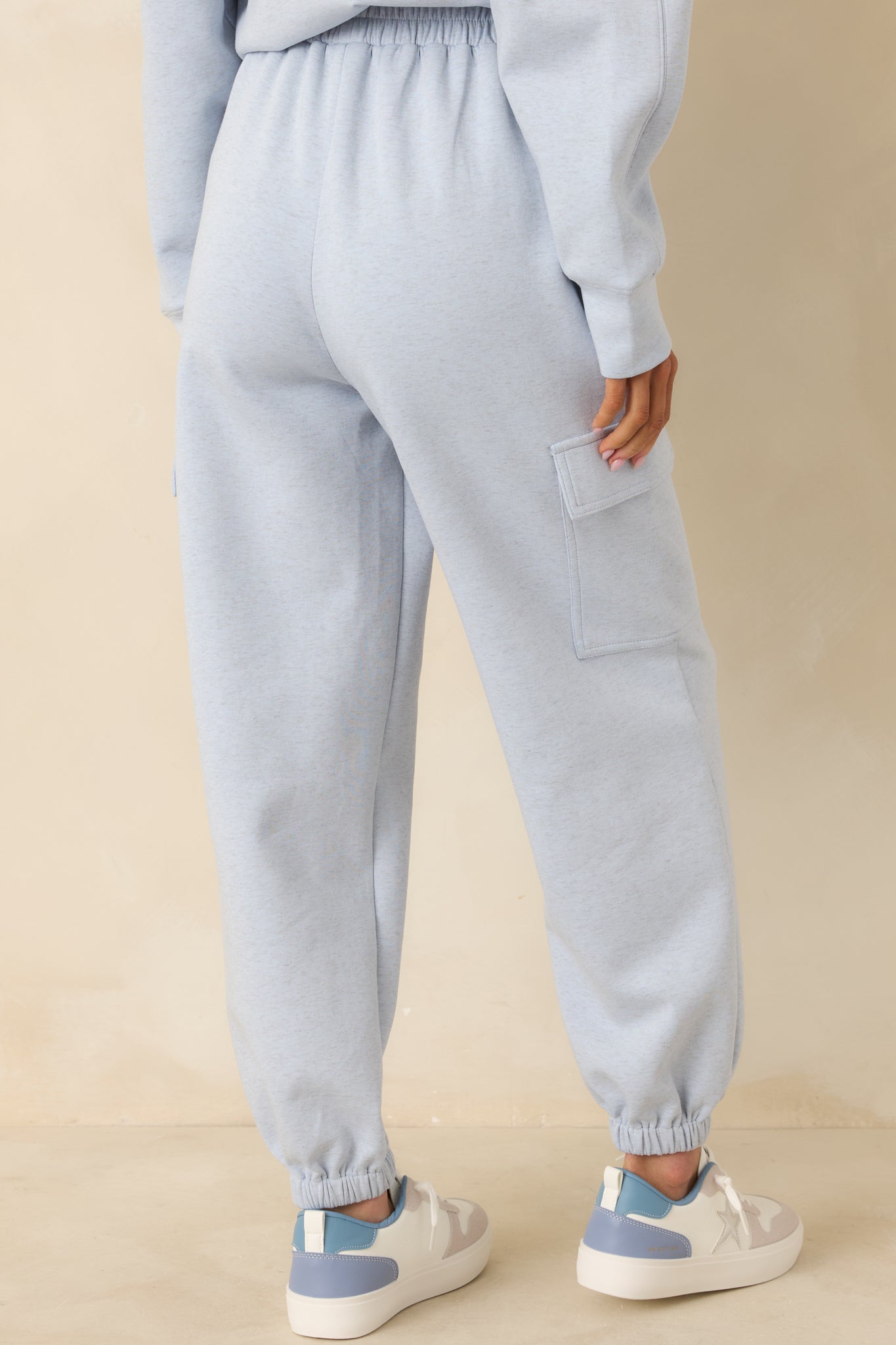 Rear view of light heather blue joggers showing relaxed fit and elastic ankle cuffs.