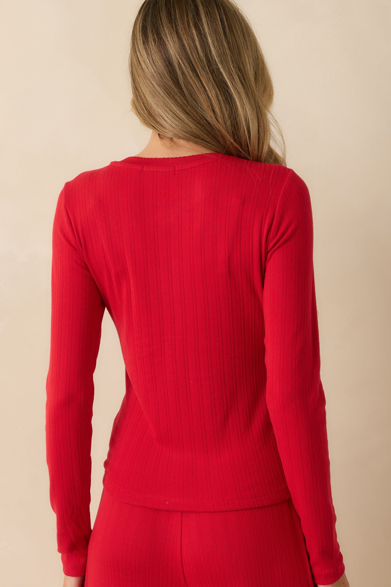 Rear view of red long-sleeve henley pajama top, showing fitted silhouette, ribbed texture, and smooth pointelle knit.