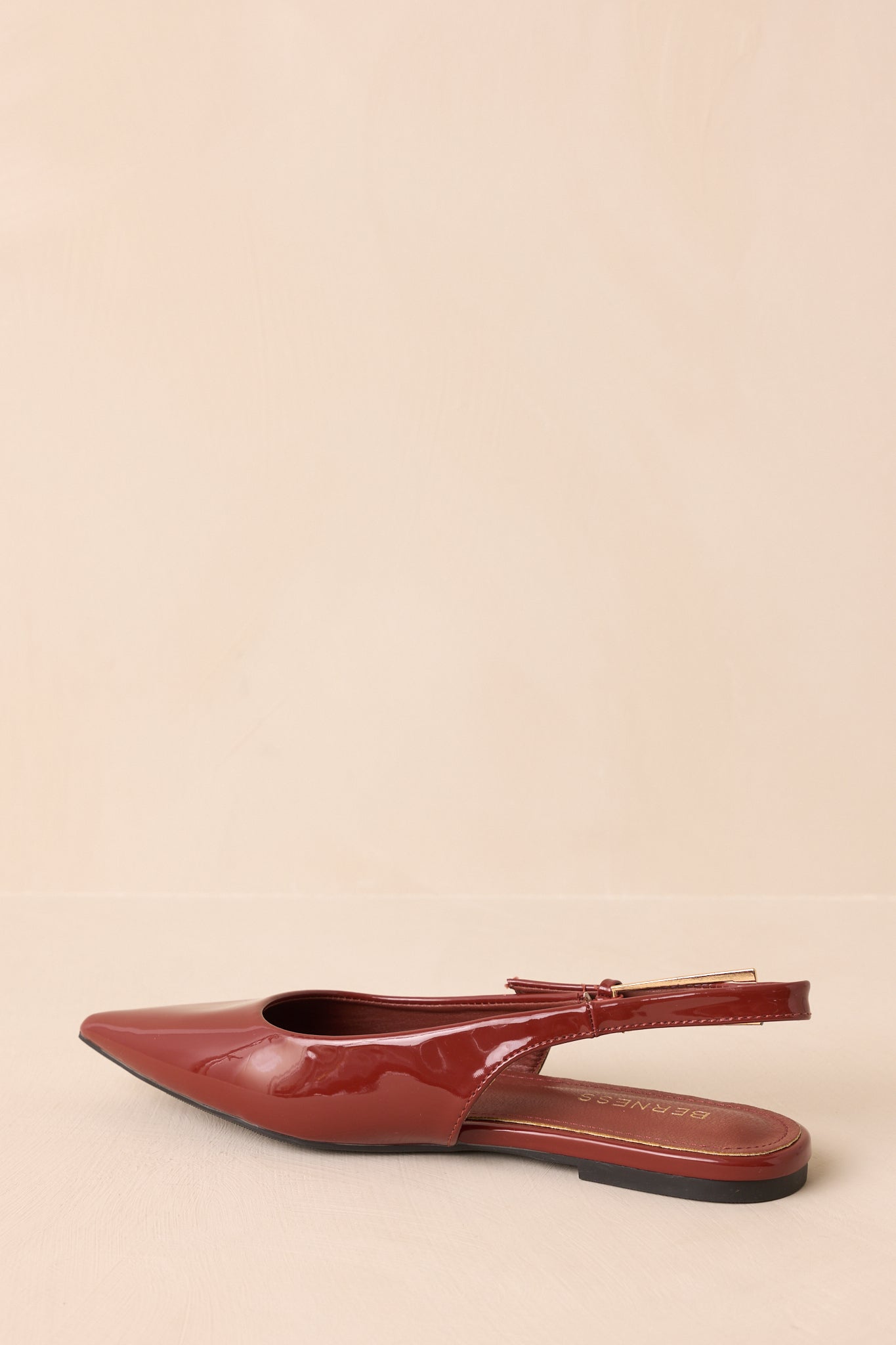 Rear view of copper brown slingback flats showing the flat sole and slim strap wrapping around the heel.