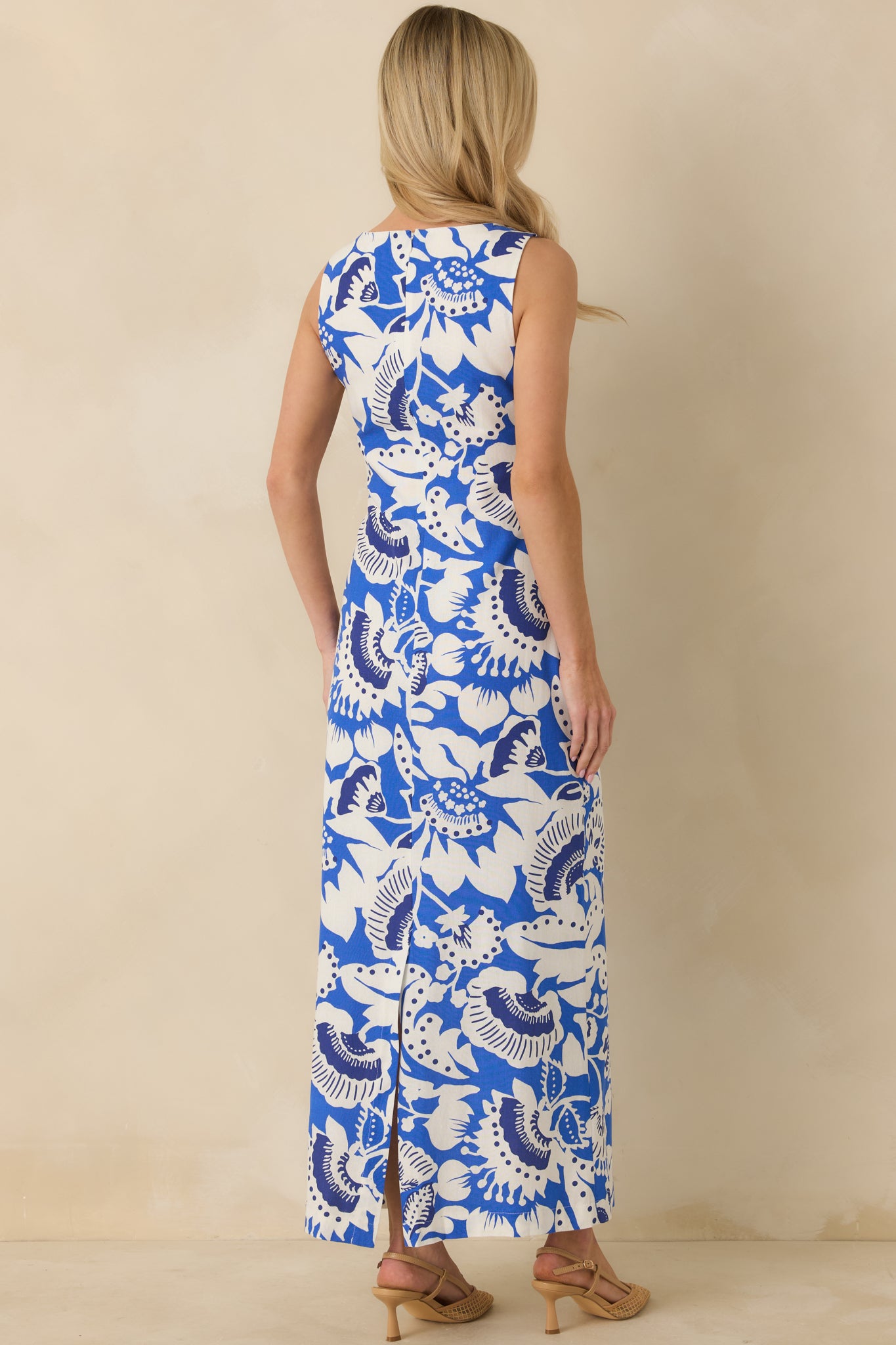 Rear view of the sleeveless blue and white maxi dress showing the hidden zipper closure, wide straps, and flowing silhouette.