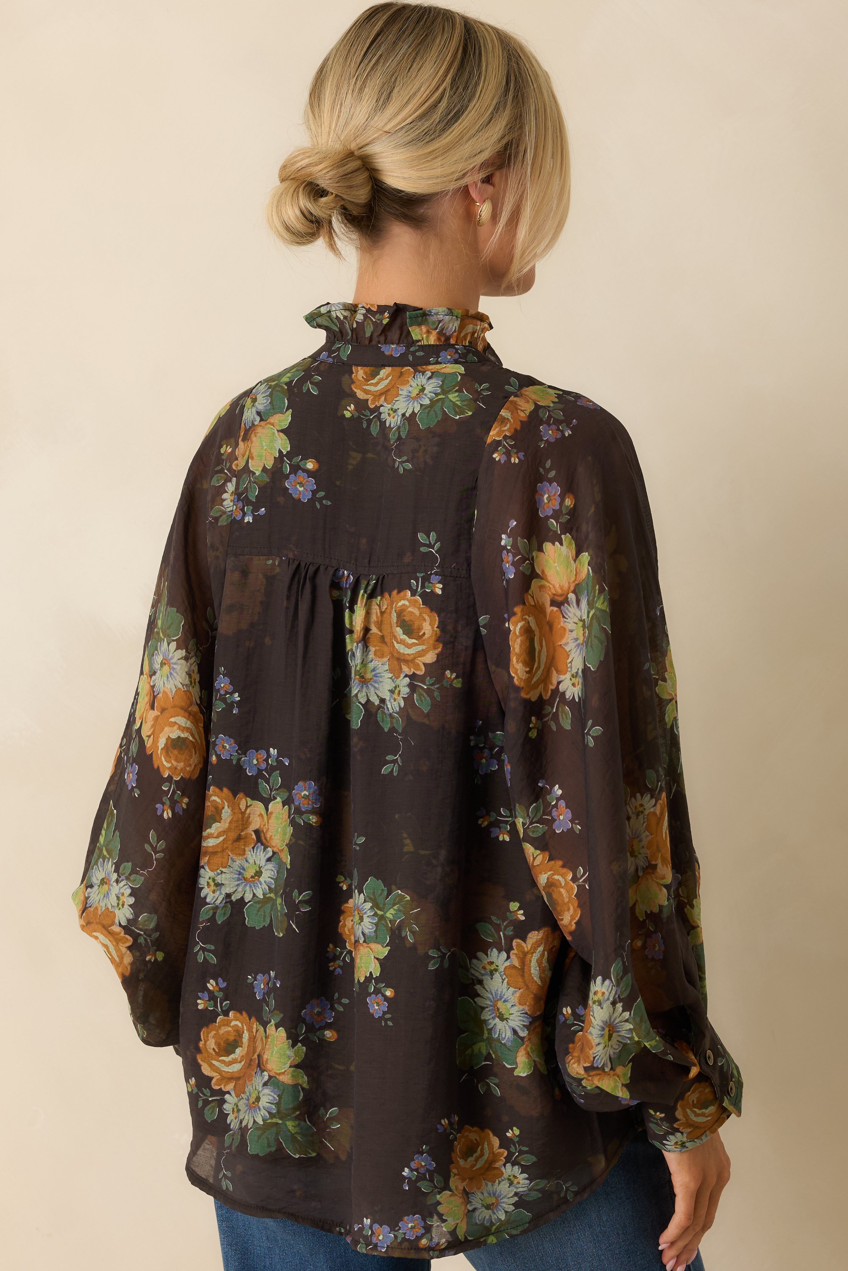 Rear view of the brown floral blouse showing long peasant sleeves and relaxed, flowy silhouette.