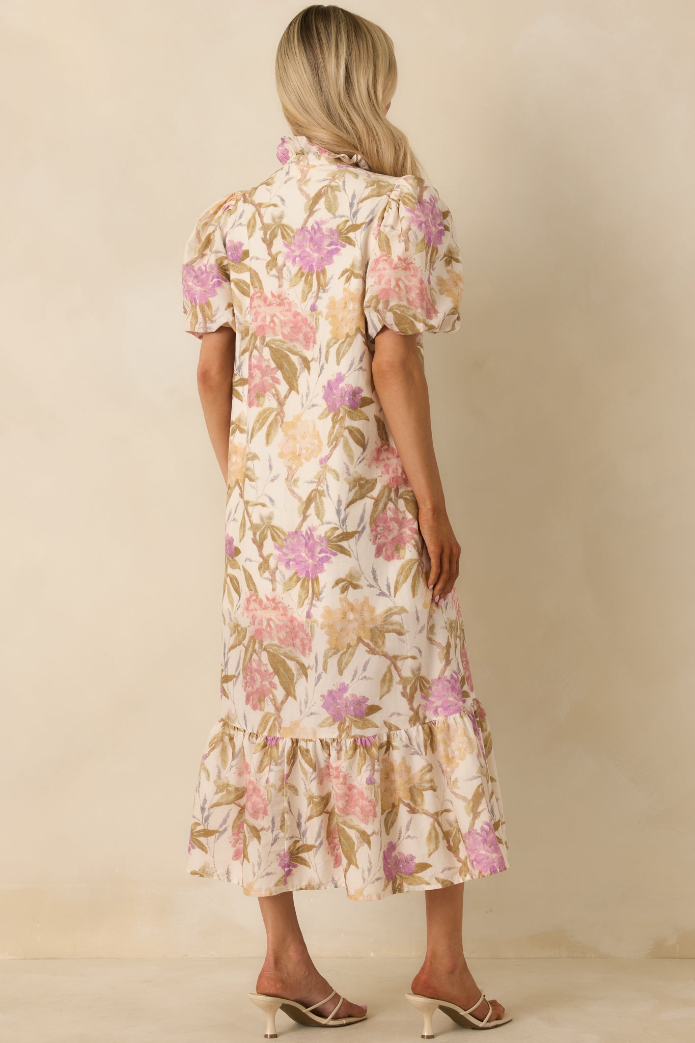Rear view of the ivory multi floral midi dress showing the relaxed drape, gathered ruffle hem, and smooth pull-on design that falls comfortably without feeling oversized.