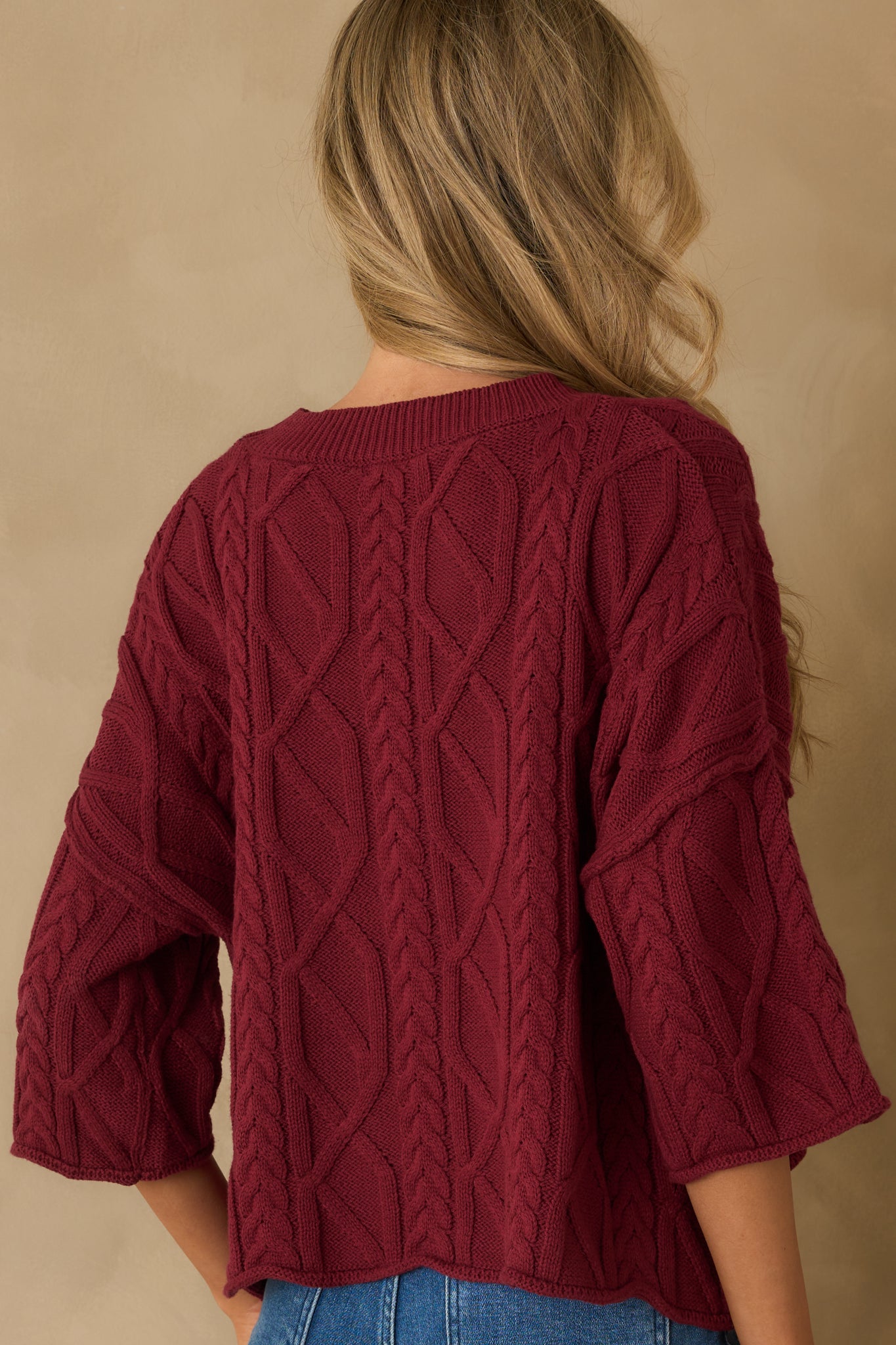 Rear view of the sweater showing the relaxed fit with rolled hems and smooth knit finish.