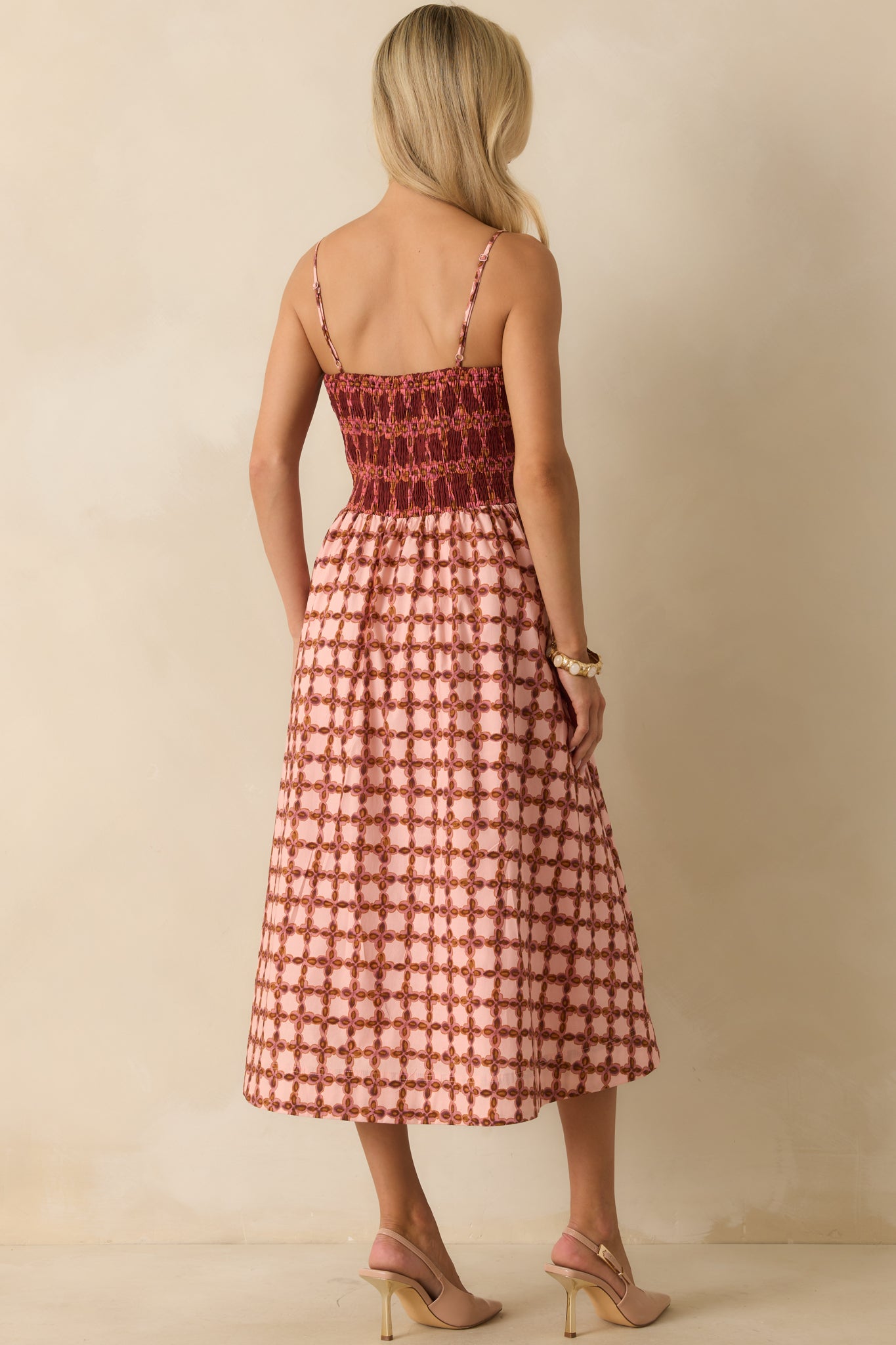 Rear view of the pink midi dress showing the smocked back panel and pleated skirt.