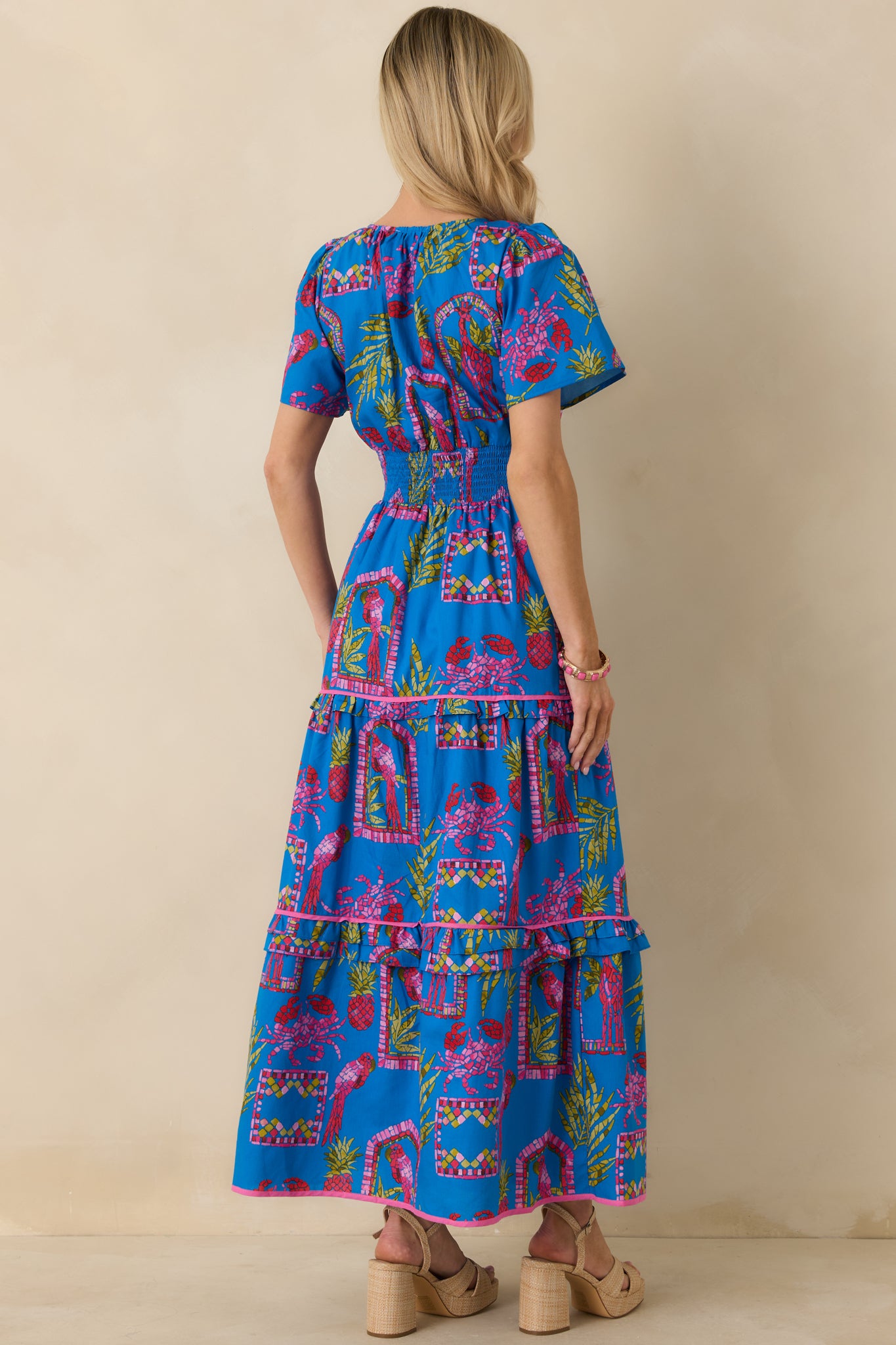 Rear view of the blue multi maxi dress showing the smocked waistband, tiered skirt, and short puff sleeves.