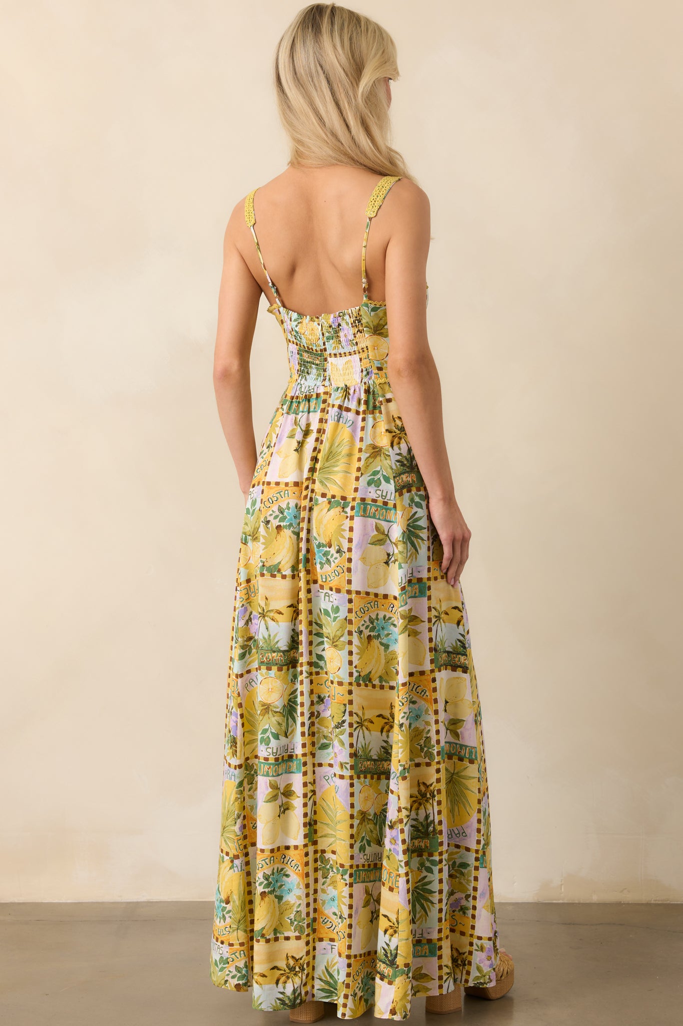 View from behind showing the smocked back panel, hidden zipper, and continuation of the tropical print across the back.