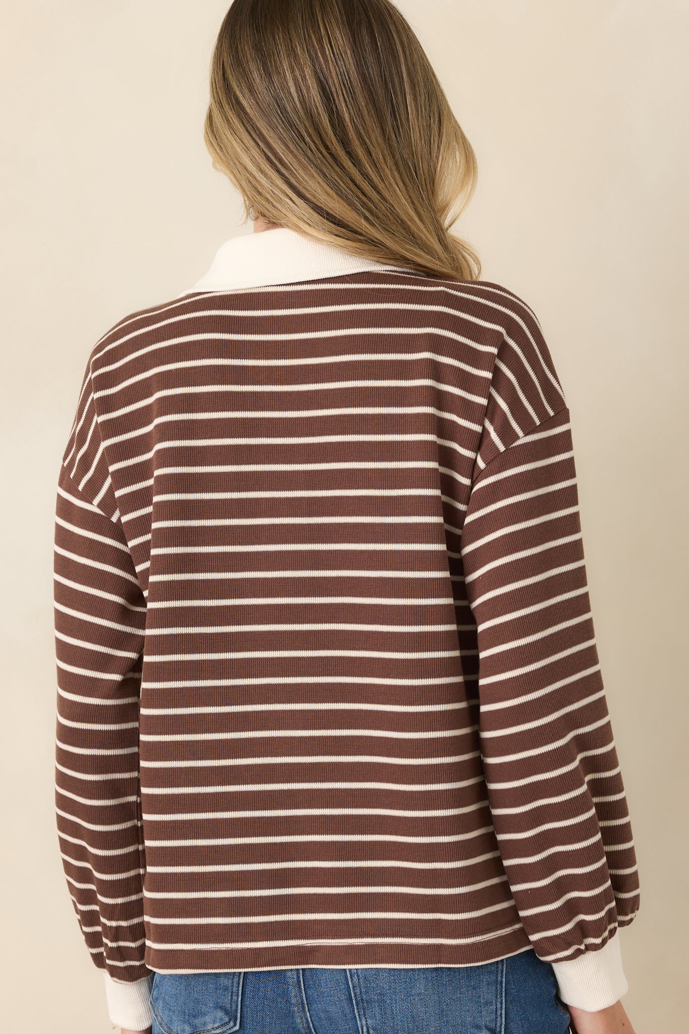 Rear view of the striped knit pullover highlighting the dropped shoulders, long sleeves, and relaxed fit.