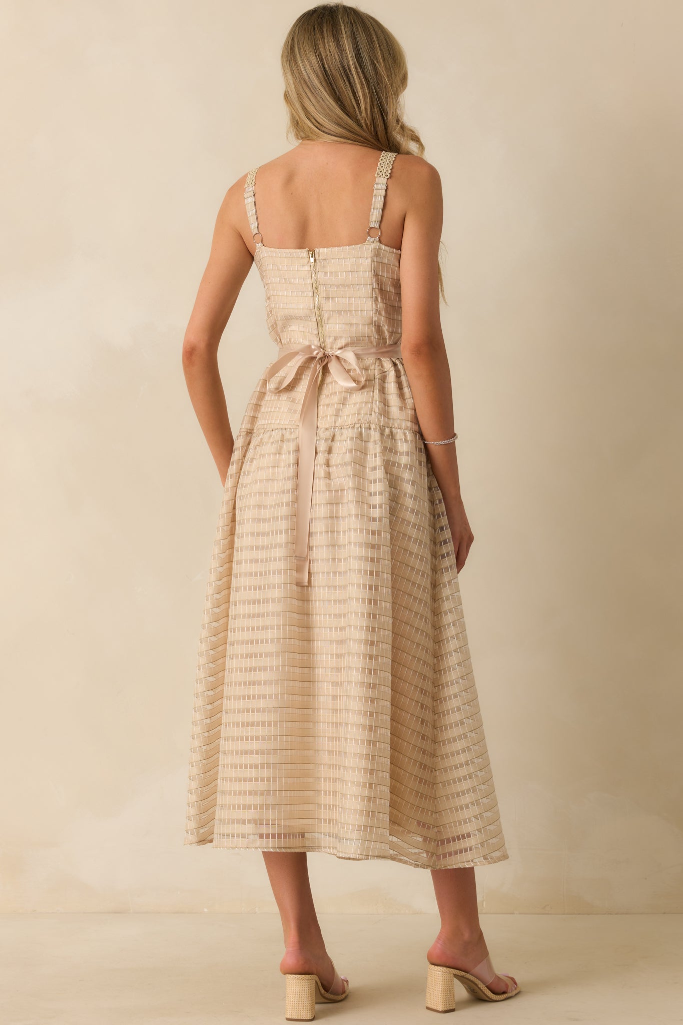 Rear view of the tan embroidered dress, showing the gold back zipper and adjustable embroidered straps.
